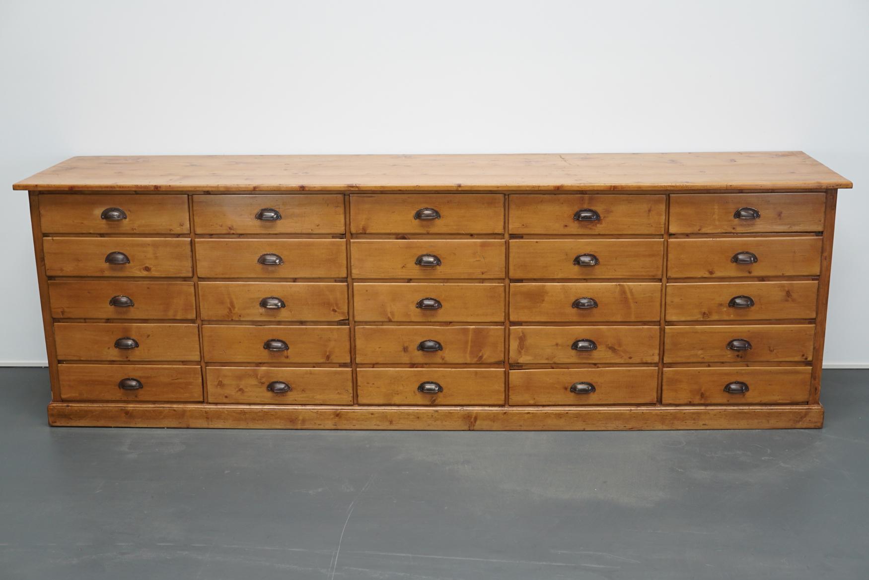 This apothecary cabinet of drawers was designed and made around the 1930s in France. The piece is made from pine and features drawers with metal cup handles. The interior dimensions of the drawers are: DWH 56 x 51 x 11.5 cm.