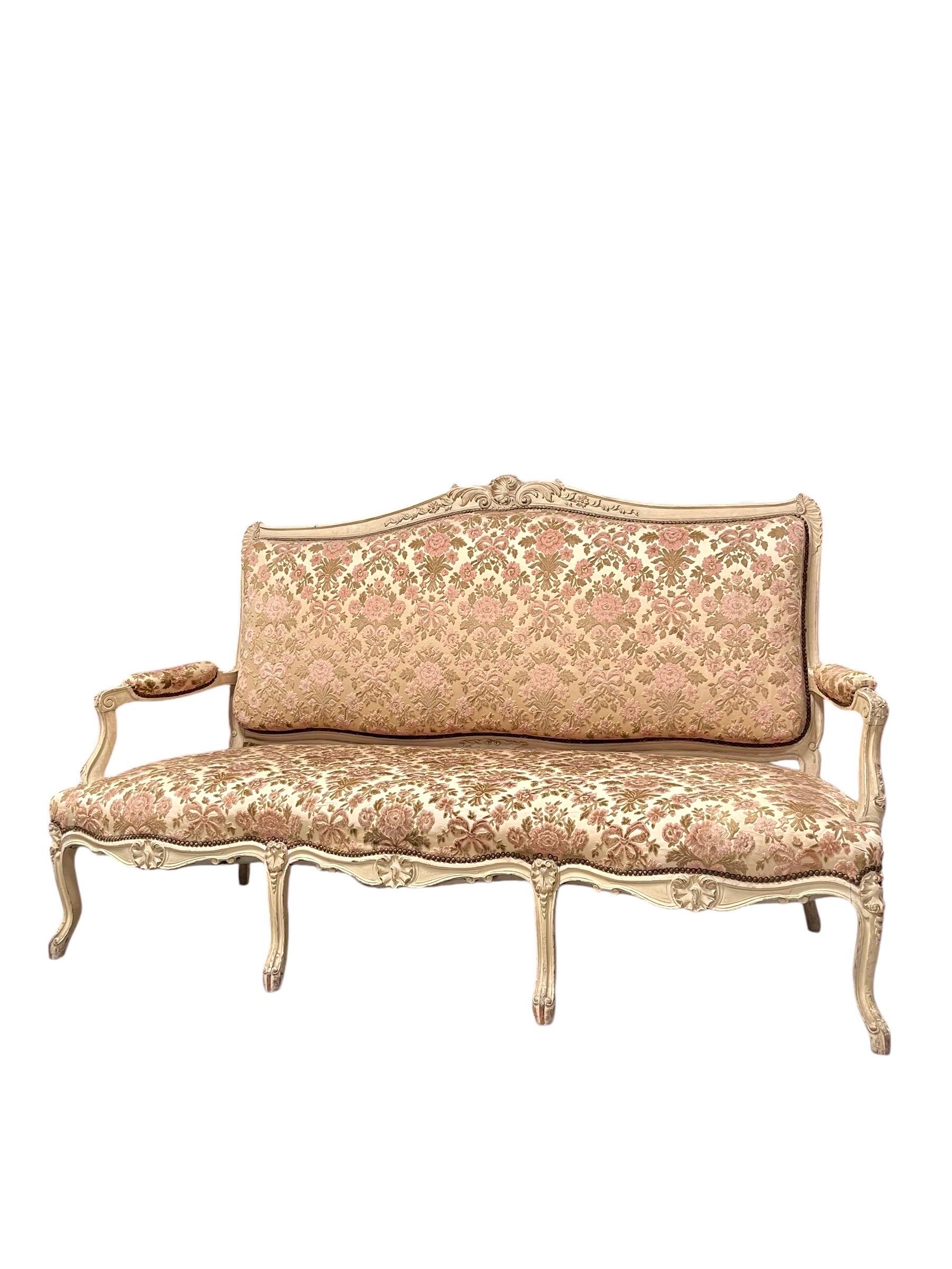 Magnifica panca da divano in legno di rechampi dipinto e dorato, modellato e scolpito con volute e fiori stilizzati.
Il divano poggia su otto gambe arcuate e ricurve, con ricadute floreali.
Braccioli con polsini, supporti curvi e modellati.
Seduta