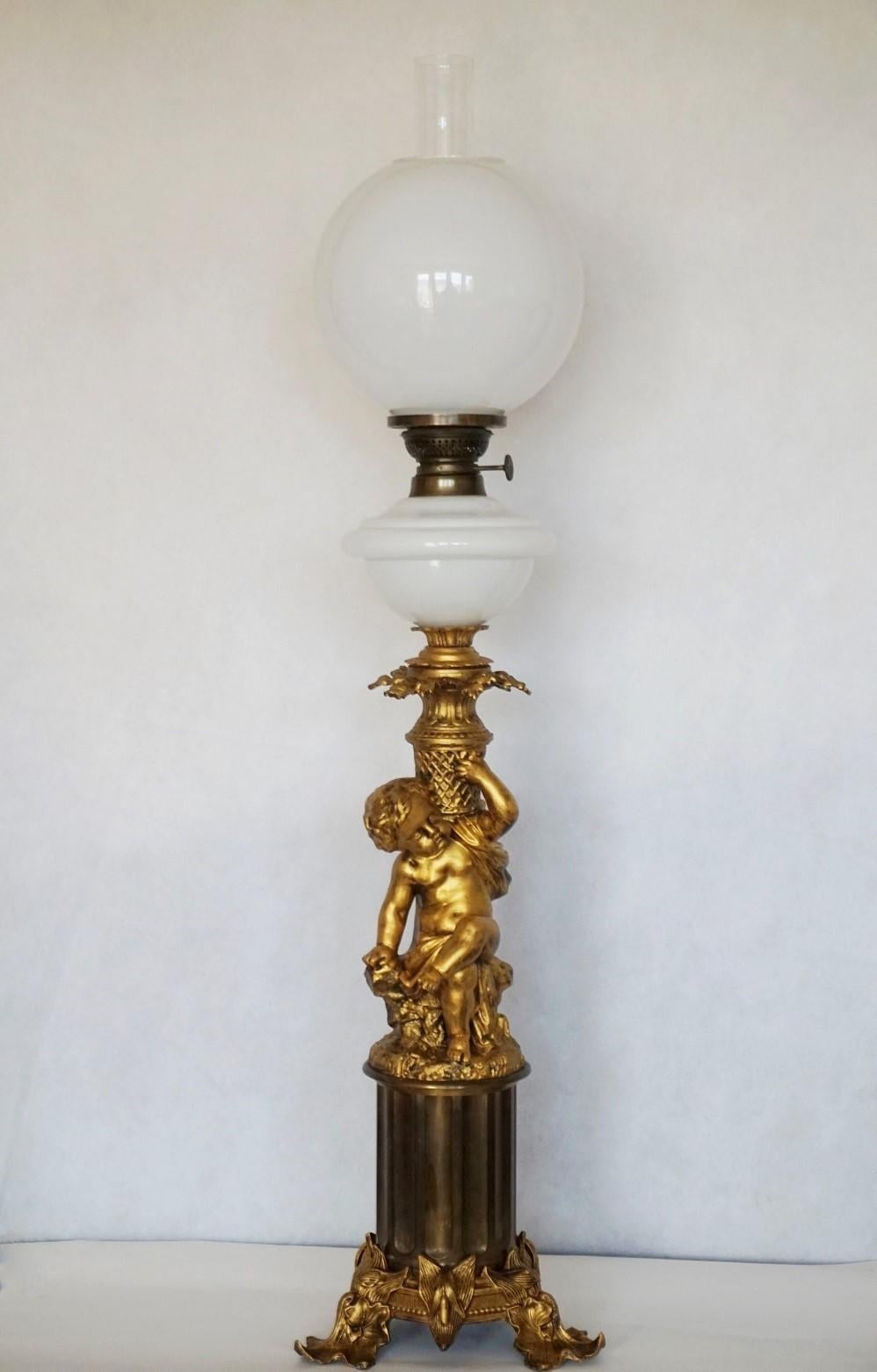 Superbe grande lampe à huile de bibliothèque de style victorien en bronze doré convertie à l'électricité, France 1870-1879. Bénitier et abat-jour originaux en verre soufflé à la main avec cheminée en verre clair. Magnifique chérubin assis sur un