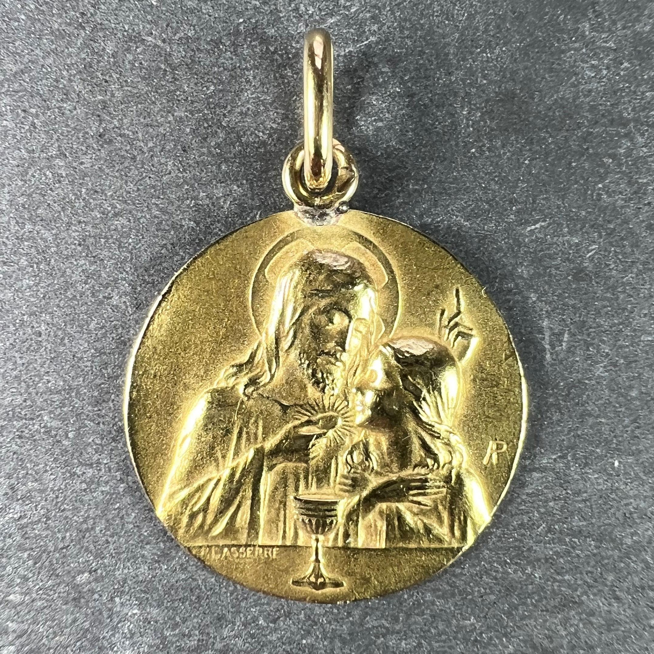 A French 18 karat (18K) yellow gold charm pendant designed as a medal depicting Jesus preparing the holy communion to one side. Signed Lasserre, with the eagle’s head for 18 karat gold and French manufacture and a partial unknown maker's