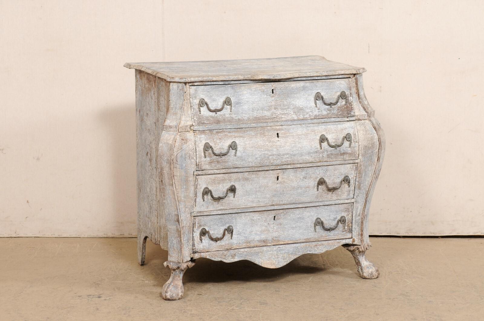 A French bombé style painted wood commode from the turn of the 18th and 19th century. This antique chest from France features a shapely top with canted front corners and center/front scallop, atop a case that houses four full-sized chests flanked