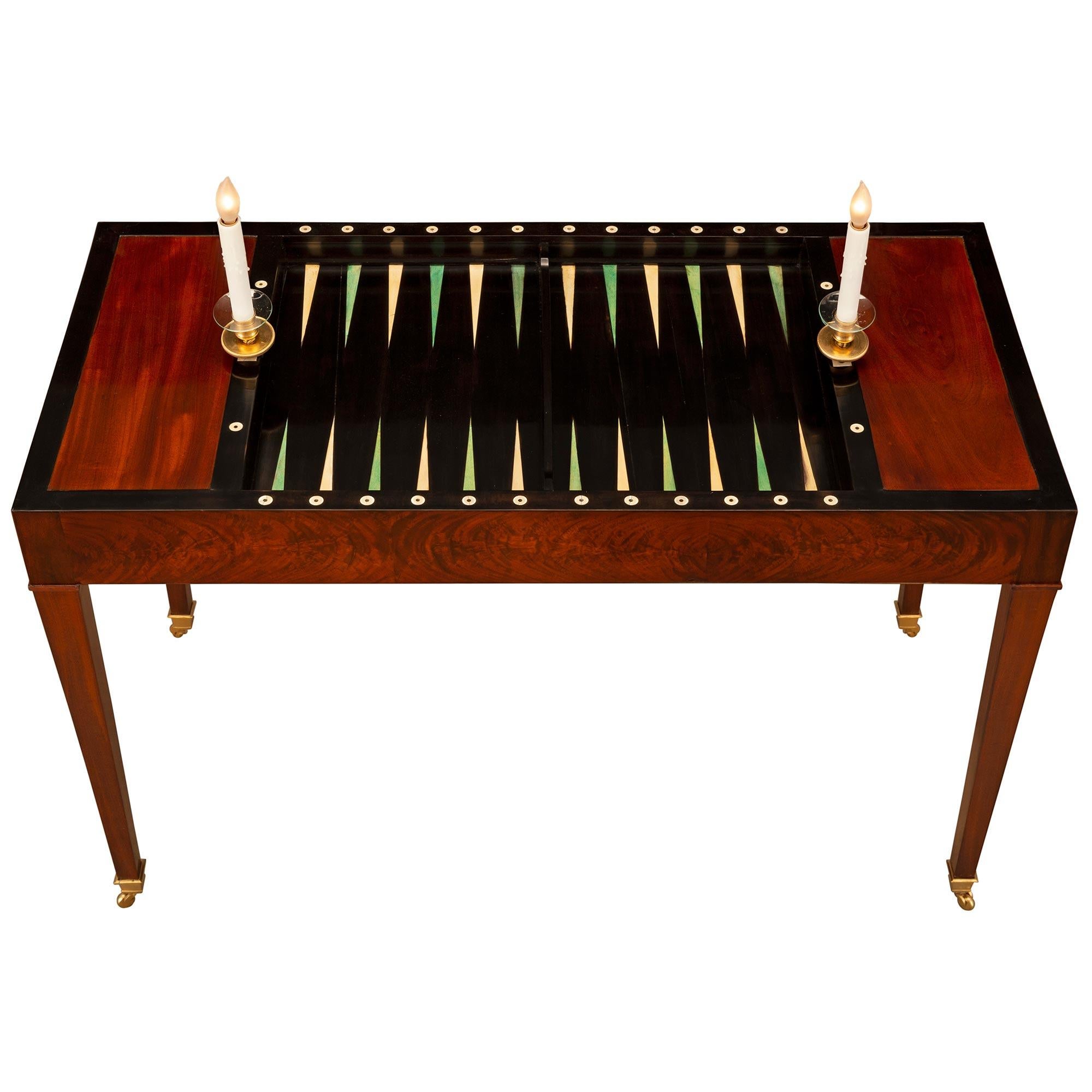 A beautiful and most elegant French late 18th century Louis XVI period Mahogany and ormolu electrified Tric Trac games table. The rectangular table is raised by square tapered legs with their original ormolu casters. The straight frieze displays
