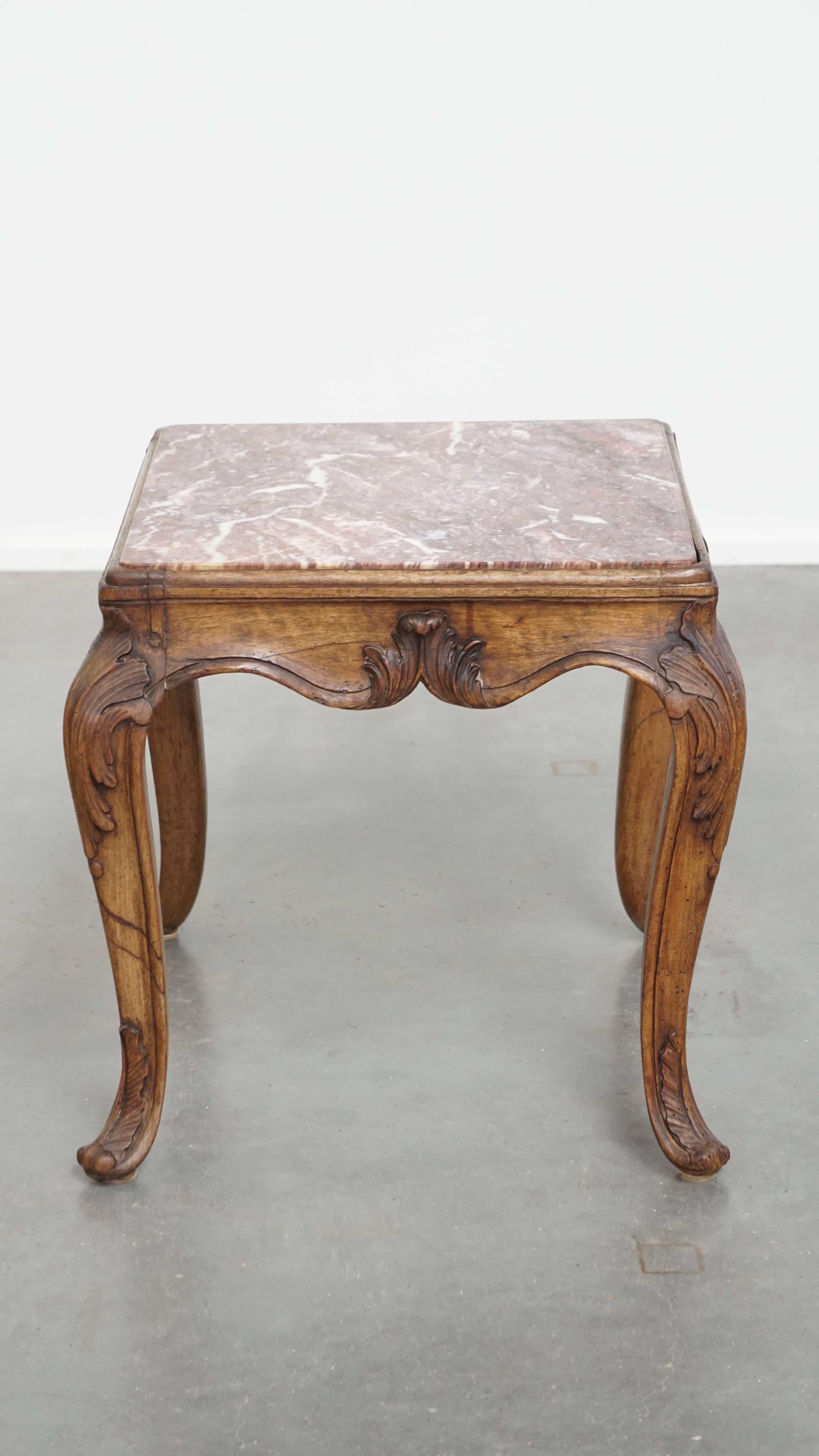 Cette table d'appoint ancienne de forme carrée datant de la fin du 18e siècle est très belle. Il se compose d'un cadre en bois avec de belles sculptures et d'un superbe plateau en marbre. Cette table s'intègre bien dans presque tous les intérieurs
