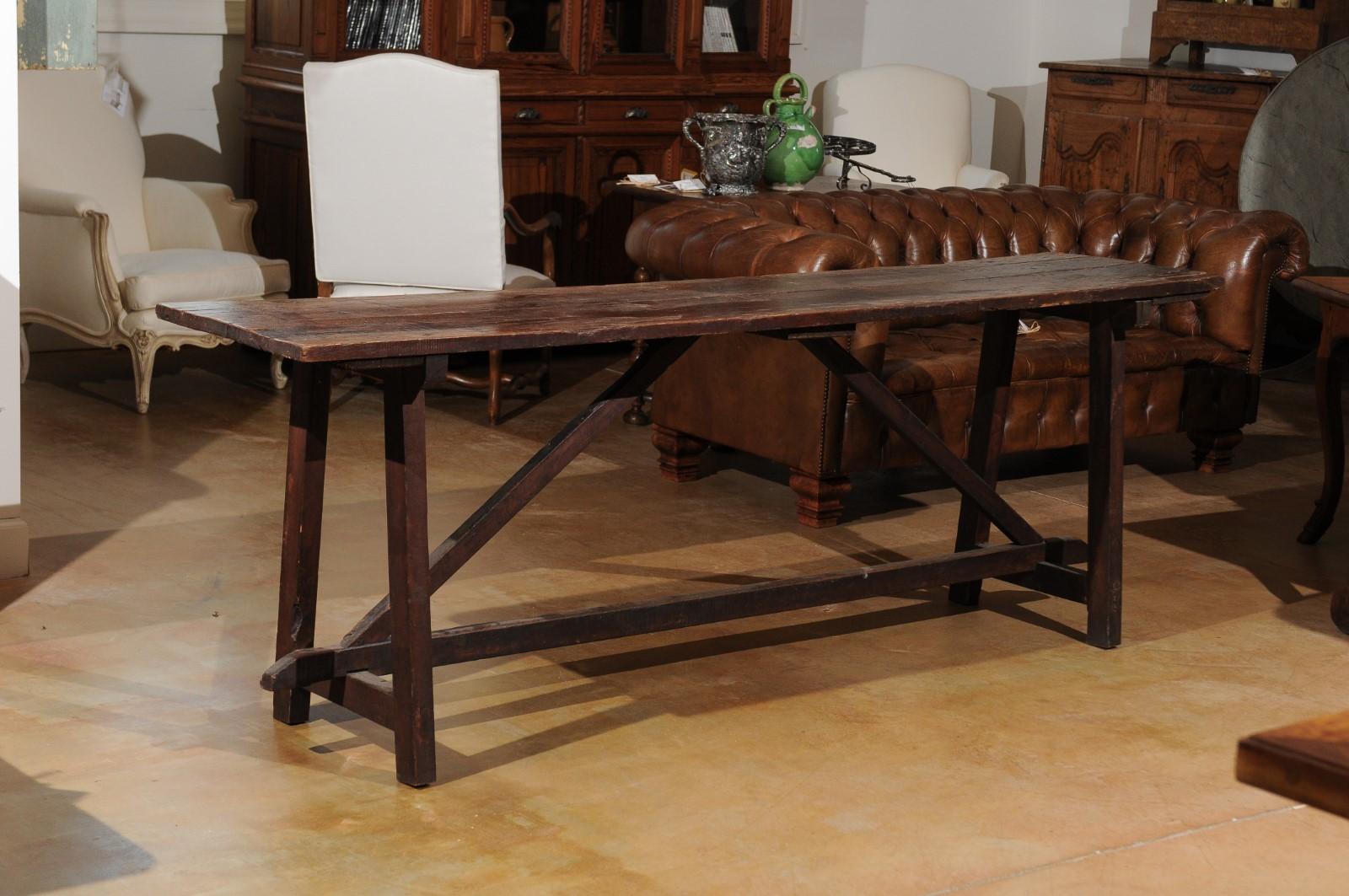 A French walnut sofa table from the late 18th century, with trestle base and great patina. Born in the later years of the 18th century at a time when France was witnessing the fall of the Ancient Régime, this walnut sofa table features a rectangular