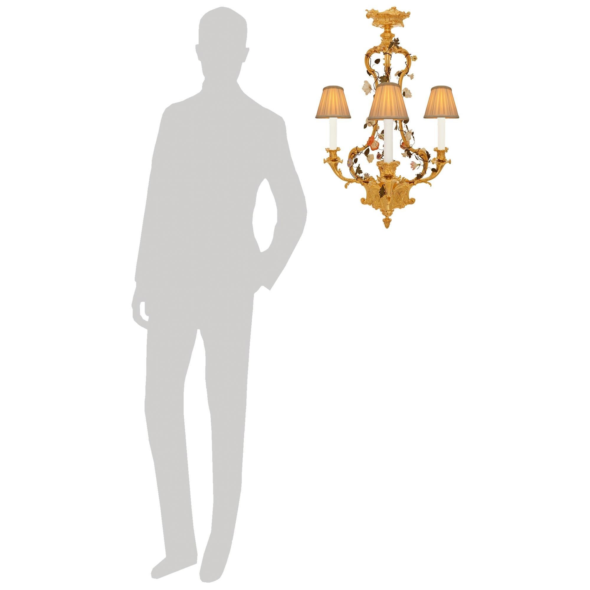 Un elegantissimo e unico lampadario francese della fine del XIX secolo in stile Belle Epoque, con ormeggio, metallo stampato e porcellana di Saxe. Questo splendido lampadario a tre bracci è centrato da una ghiera rovesciata in Ormolu e da una placca