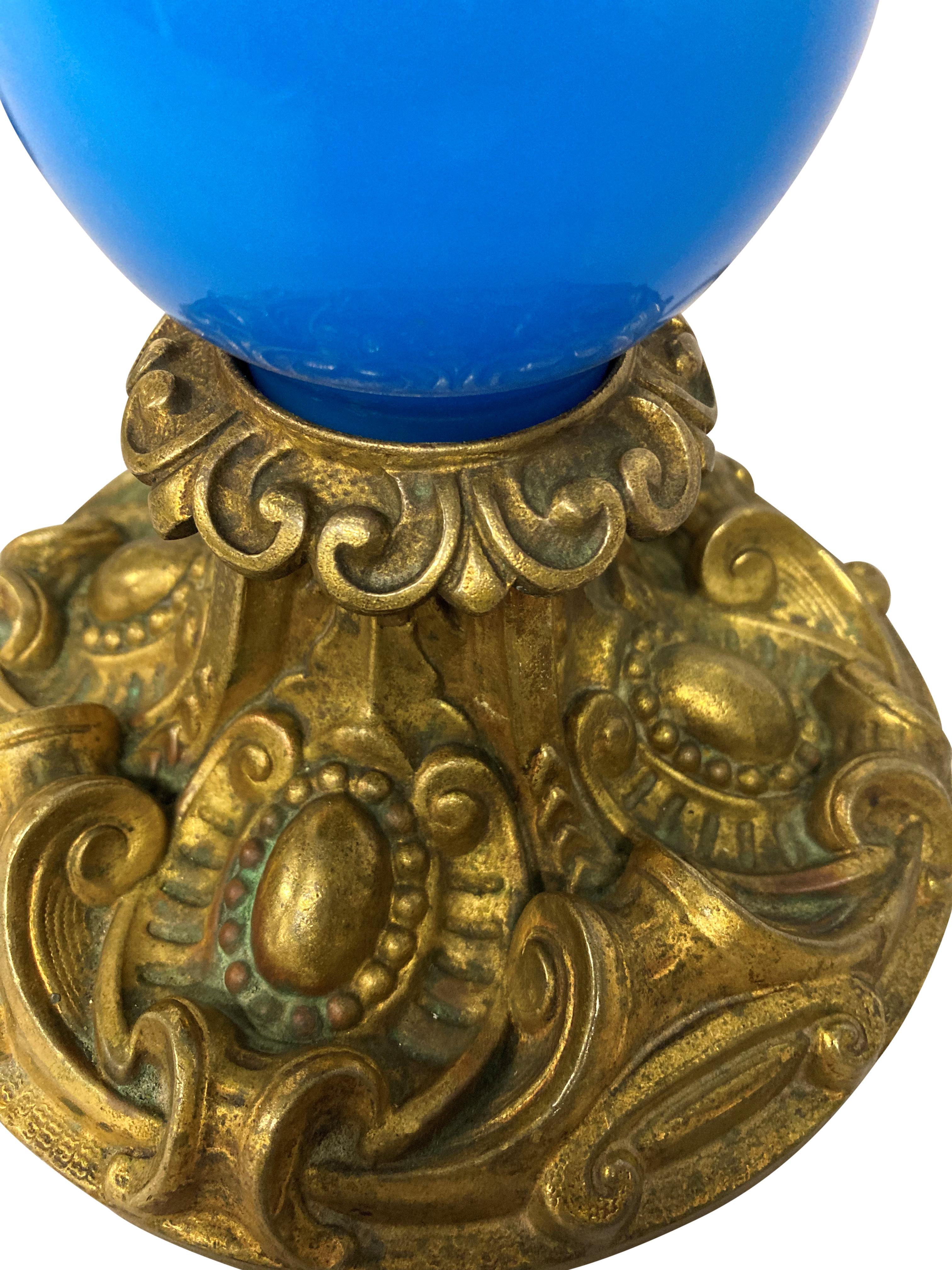 Une lampe de table française de la fin du XIXe siècle en verre bleu, avec des montures décoratives en métal doré. Anciennement pour le pétrole.