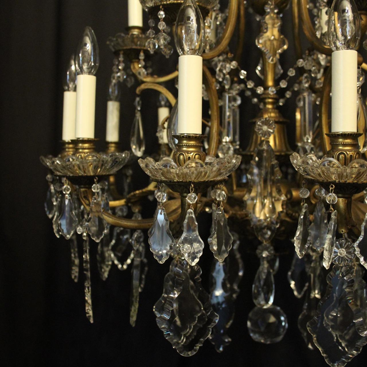 A quality French gilded bronze and crystal 18 light birdcage form double tiered antique 19th century chandelier, the leaf clad scrolling arms with glass bobeche drip pans and reeded bulbous candle sconces, issuing from an foliated cage form interior