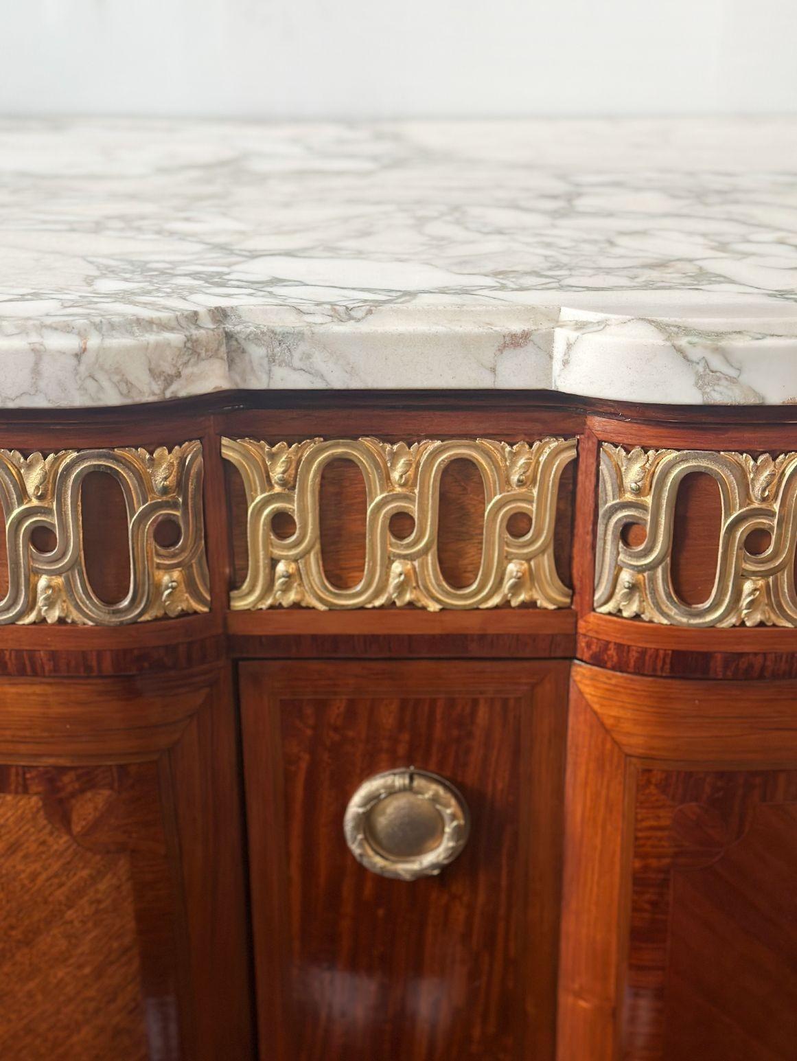 Eleganter französischer Schrank im Louis-XVI-Stil des späten 19. Jahrhunderts mit weißer Marmorplatte und bronzenen Beschlagdetails, die das Stück umgeben. Die Cabriole-Beine sind fein mit Bronzebeschlägen verziert, und die floralen Intarsien auf