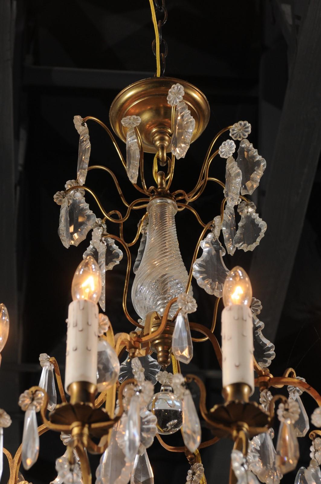 A French 12-light crystal chandelier from the late 19th century, with brass armature and pendeloques. Born in France during the last quarter of the 19th century, this exquisite 12-light chandelier features a central crystal baluster motif with