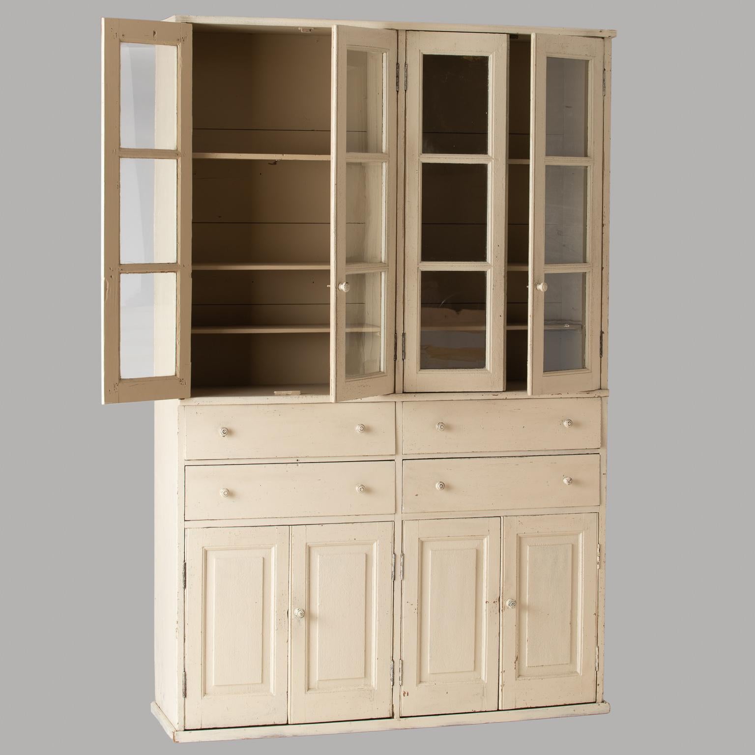 This useful cupboard has the look of a piece that might have been the focal point of a country kitchen in Provence. With glass doors and three interior shelves, it is ideal for displaying glasses, and the four centre drawers are the perfect spot for