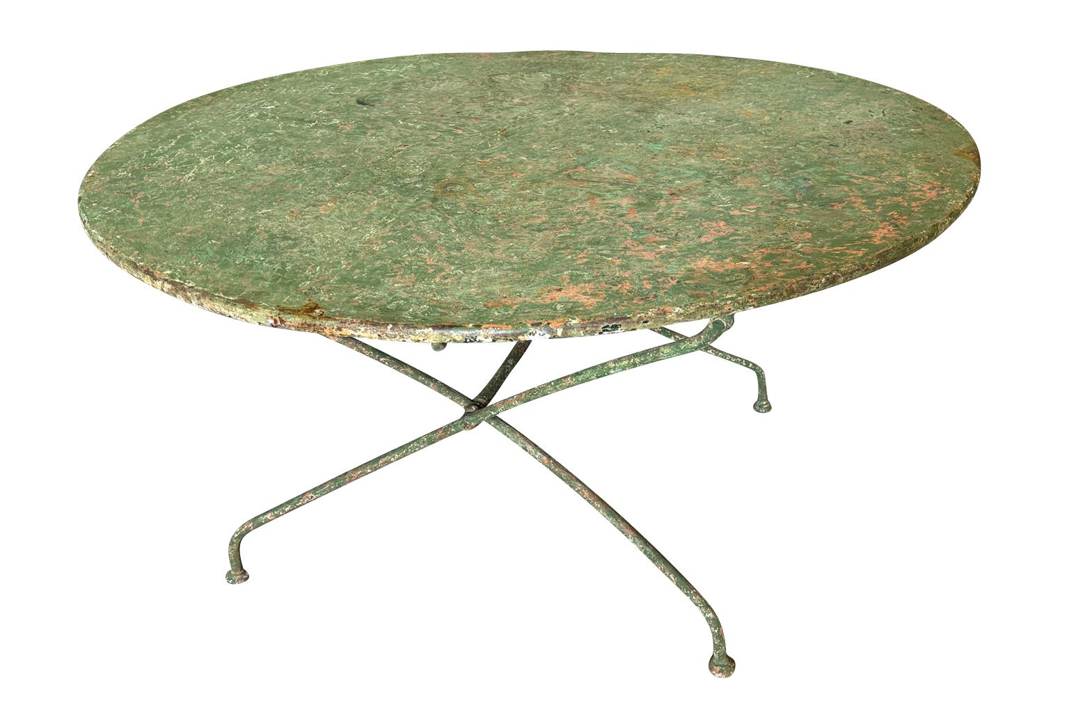 Une très charmante table de jardin ronde et pliante du sud de la France, datant de la fin du 19e siècle.  Construction robuste en fer.  Merveilleuse patine.  Parfait pour tout environnement intérieur ou extérieur. 