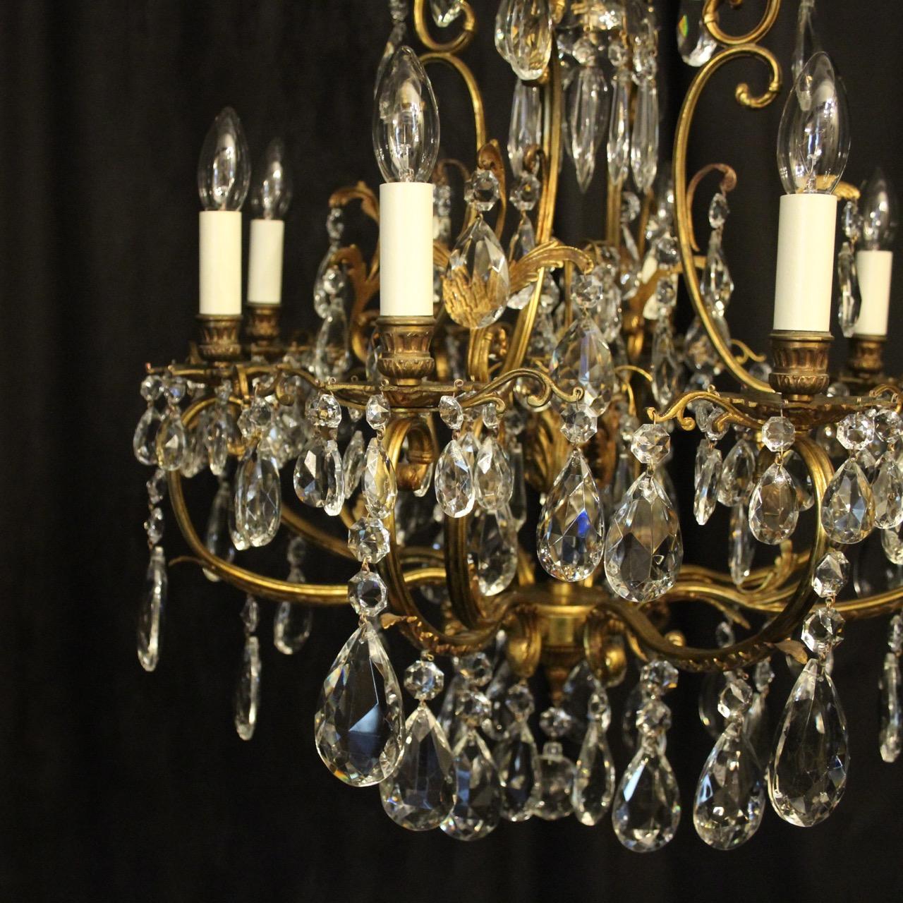 A French gilded bronze and crystal 9-light birdcage form antique chandelier, the eight leaf clad scrolling arms with ornate bobeche drip pans and bulbous candle sconces, issuing from a foliated cage form interior with a single inverted light fitting