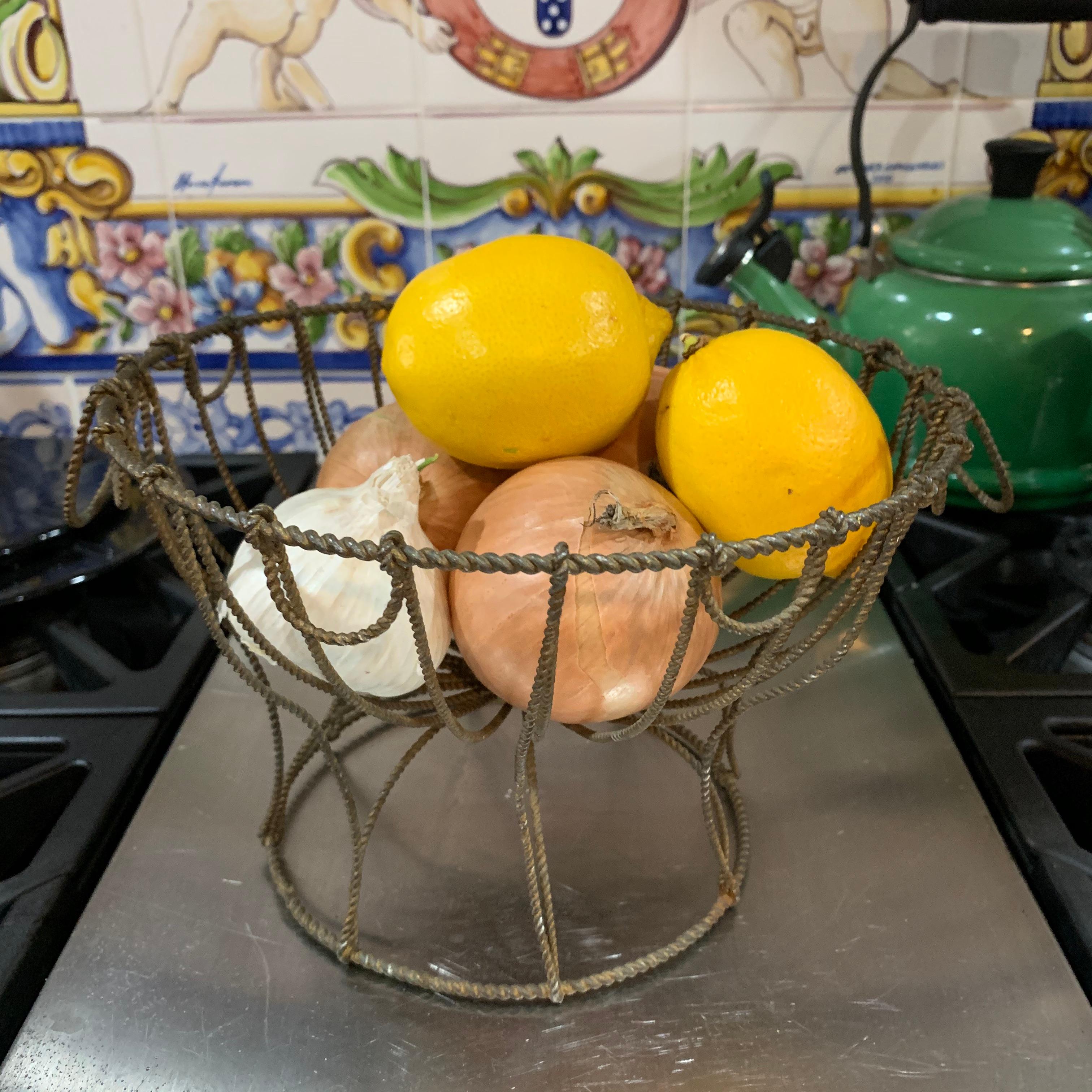 From France, circa 1890-1910, a twisted wire egg stand or kitchen basket.

A charming, rustic, hand formed metal pedestal basket with carrying handles. Seen in kitchens throughout Provençal France, for rinsing and holding fresh eggs, vegetables or