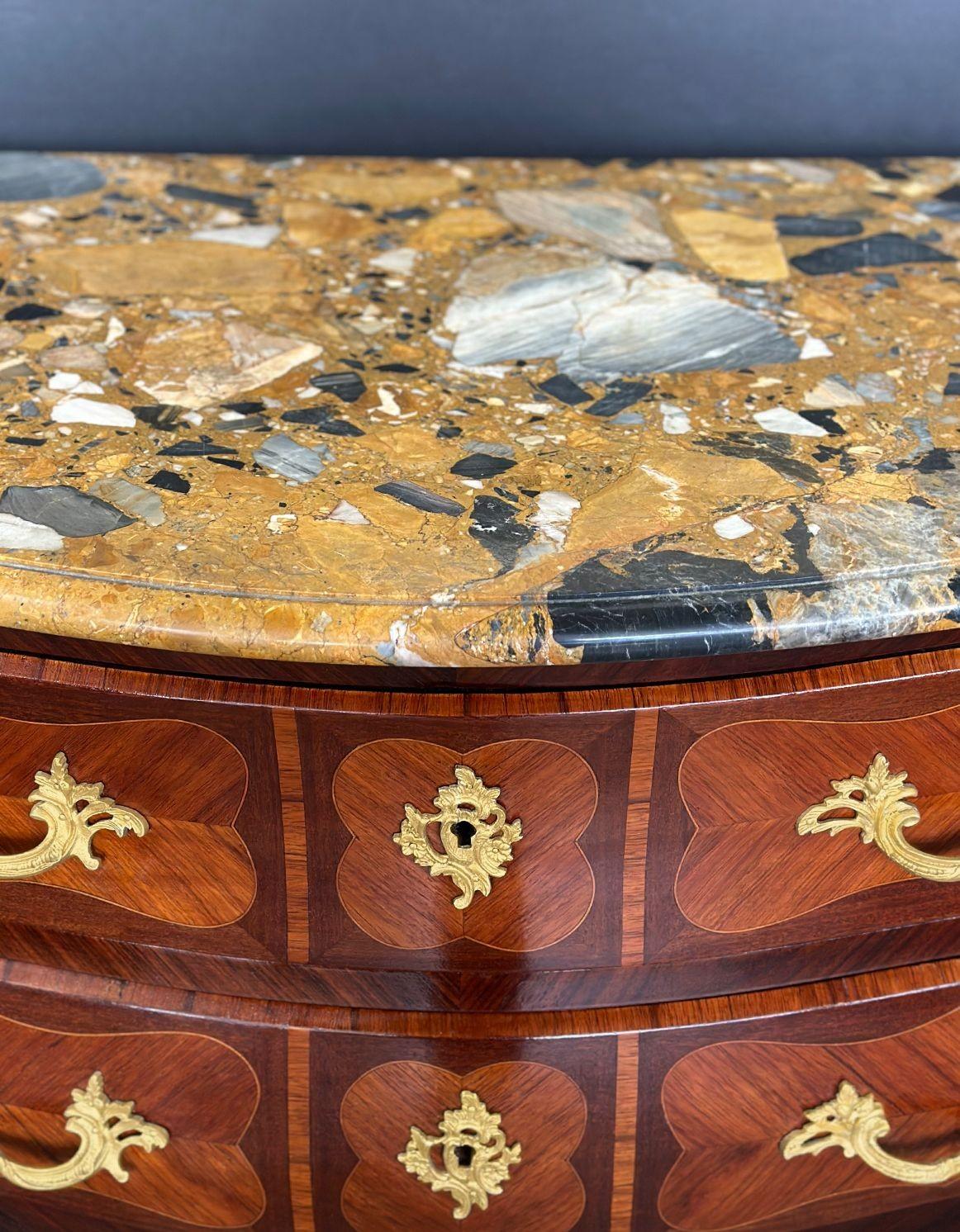 An elegant kingwood and rosewood Louis XV Bombé commode made in France in the late 19th Century, featuring a Breche d' Alep marble top over two drawers with bronze mounts handles and decorations. The piece has beautiful parquetry in each drawer as