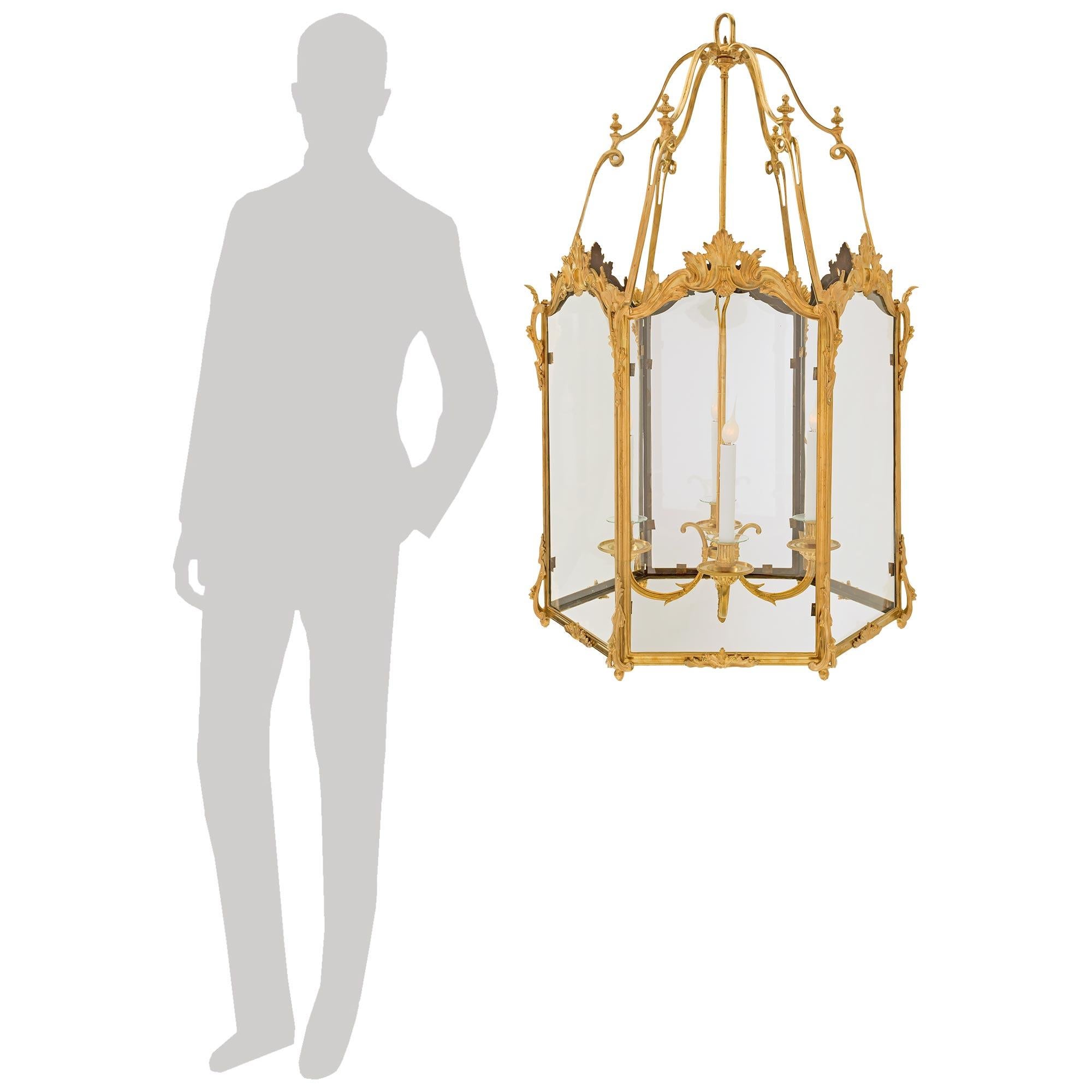 Elegante linterna francesa de gran tamaño de finales del siglo XIX, de estilo Luis XV, de ormolu y cristal. Cada plano de cristal ajustado está encajado dentro de un marco de Ormolu con un diseño moteado. Los paneles están adornados con volutas