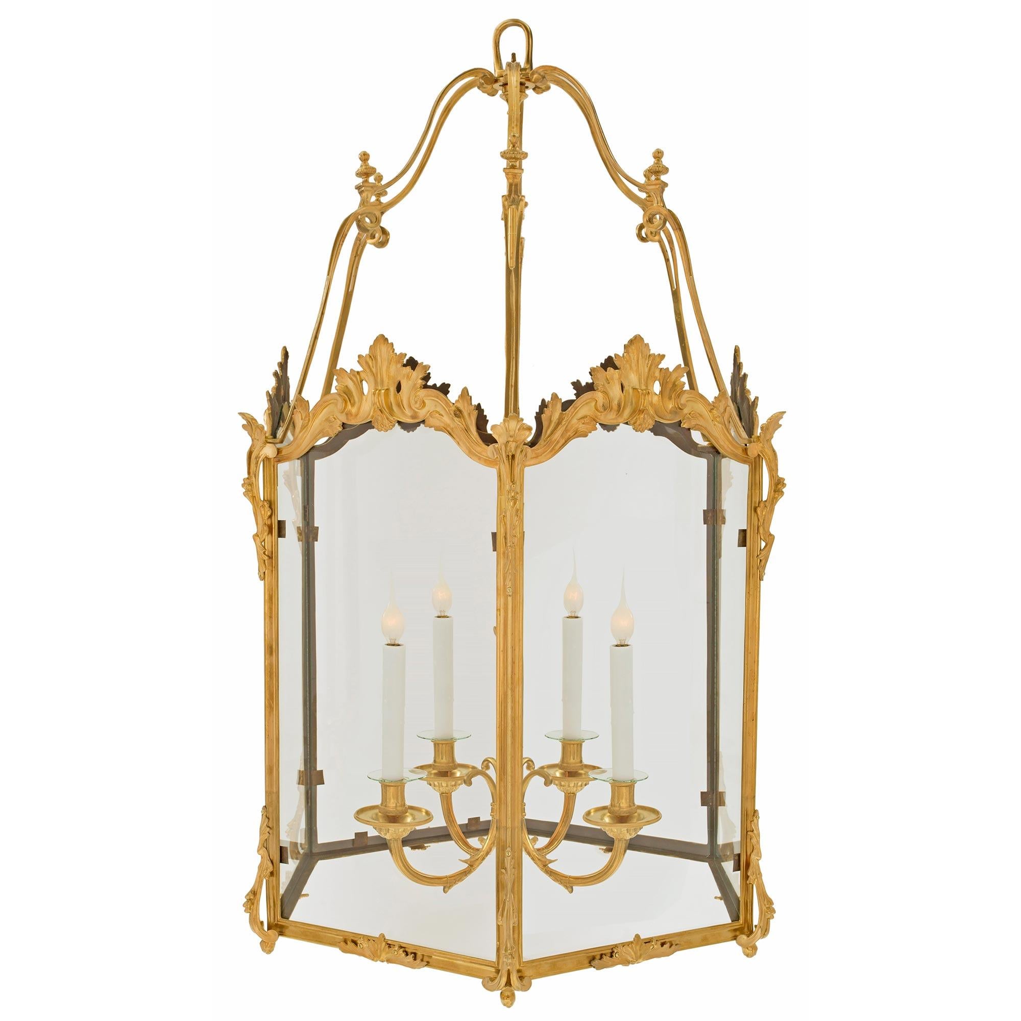 An elegant and large scale French late 19th century Louis XV st. ormolu hexagon lantern. Each fitted glass plate is fitted within an ormolu frame with a mottled design. The panels are embellished with foliate scrolls at each corner while at the