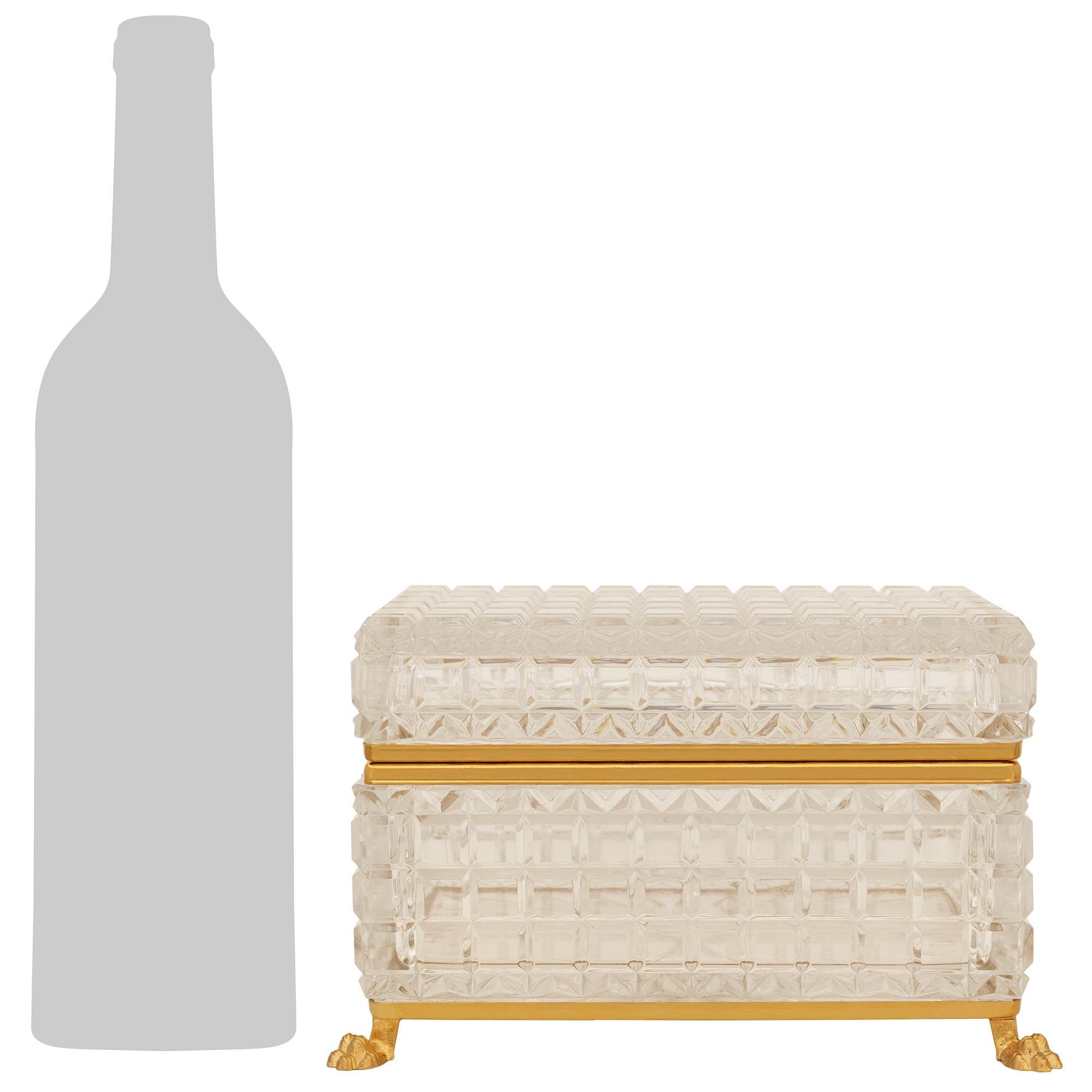 A handsome and high quality French late 19th century Louis XVI st. Baccarat Crystal and Ormolu box. This stunning rectangular shaped lidded box is raised by a bottom burnished Ormolu trim above lion paws at each corner. The thick Baccarat Crystal