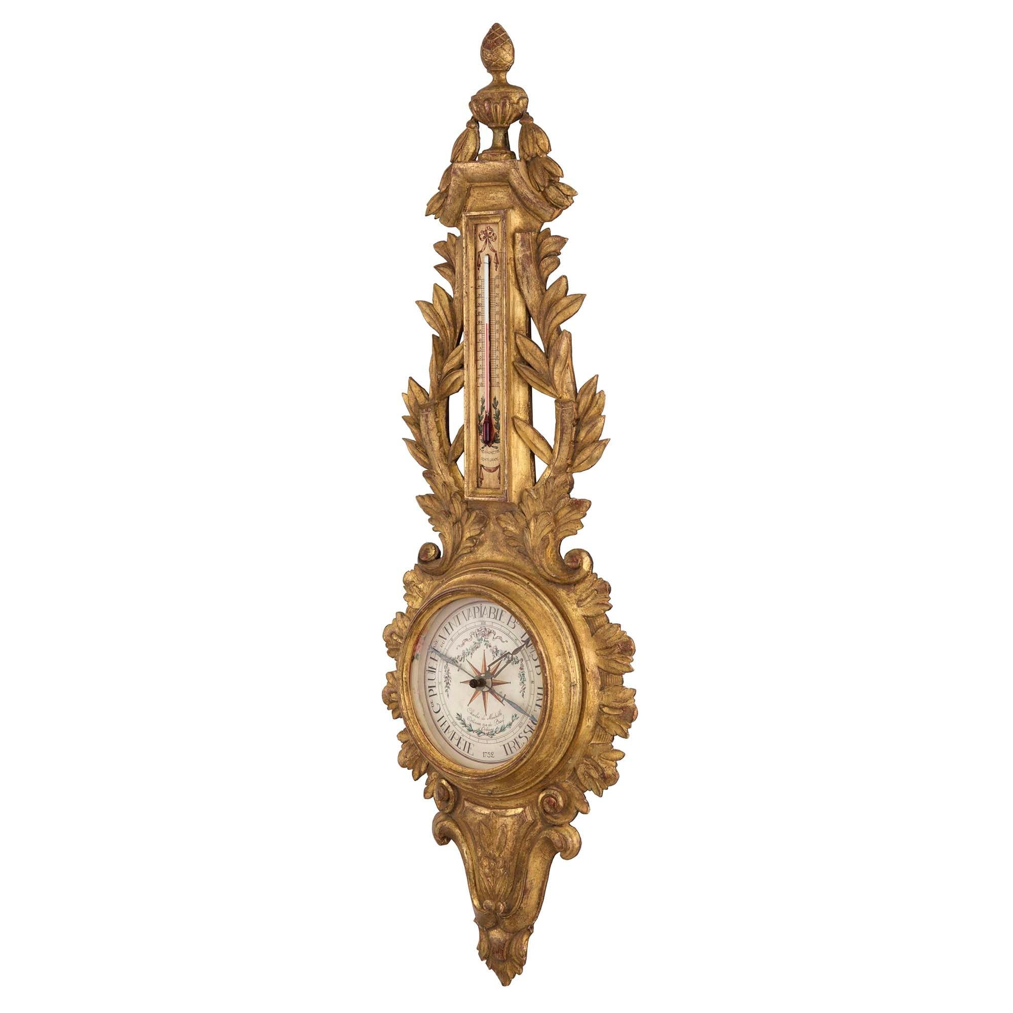 A very handsome and decorative French late 19th century Louis XVI st. giltwood barometer. Fine carvings of scrolls and foliate throughout with a lyre shape above the painted barometer façade. At the top above the thermometer is an impressive urn