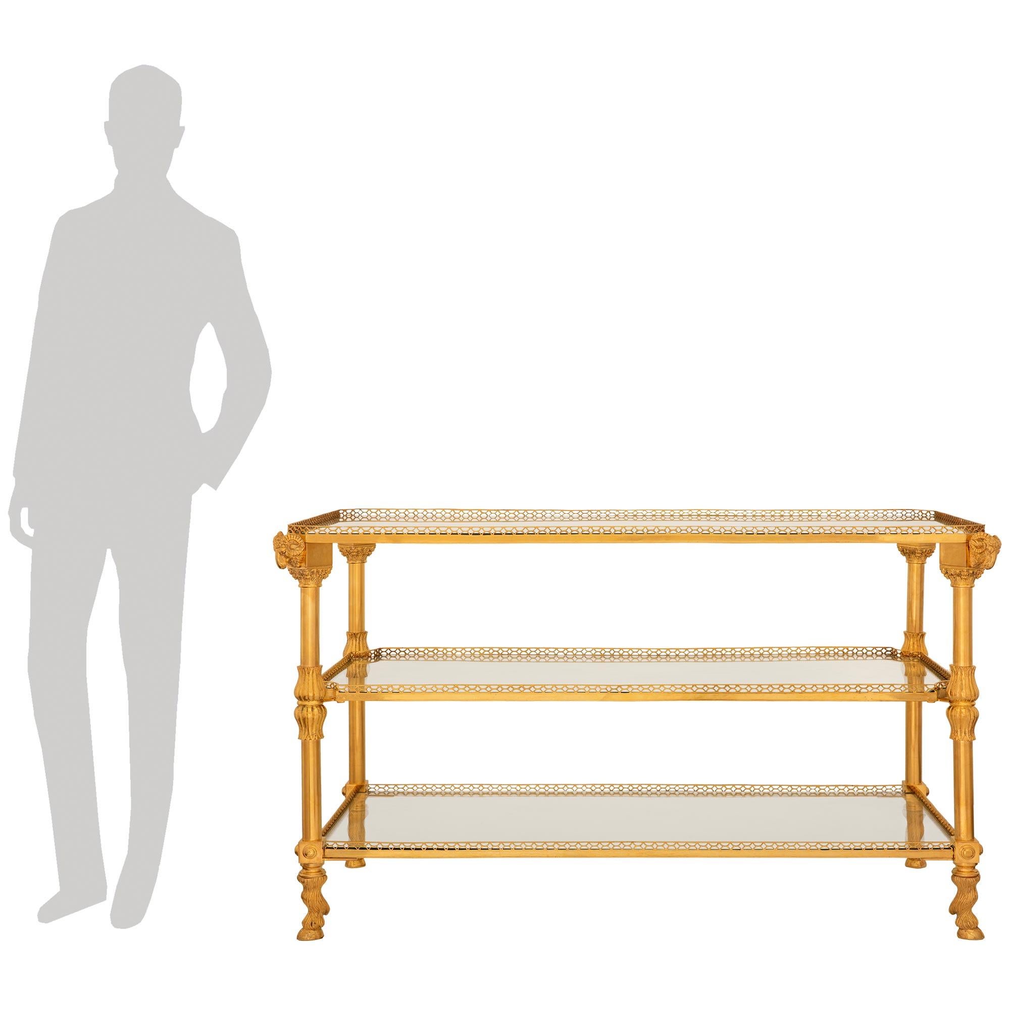 Elégante console à dessert en verre et bronze doré de style Louis XVI de la fin du XIXe siècle. Cette superbe console rectangulaire à trois niveaux est surélevée par quatre pieds avec des paires de réserves en forme de bulbe de tulipe et repose sur