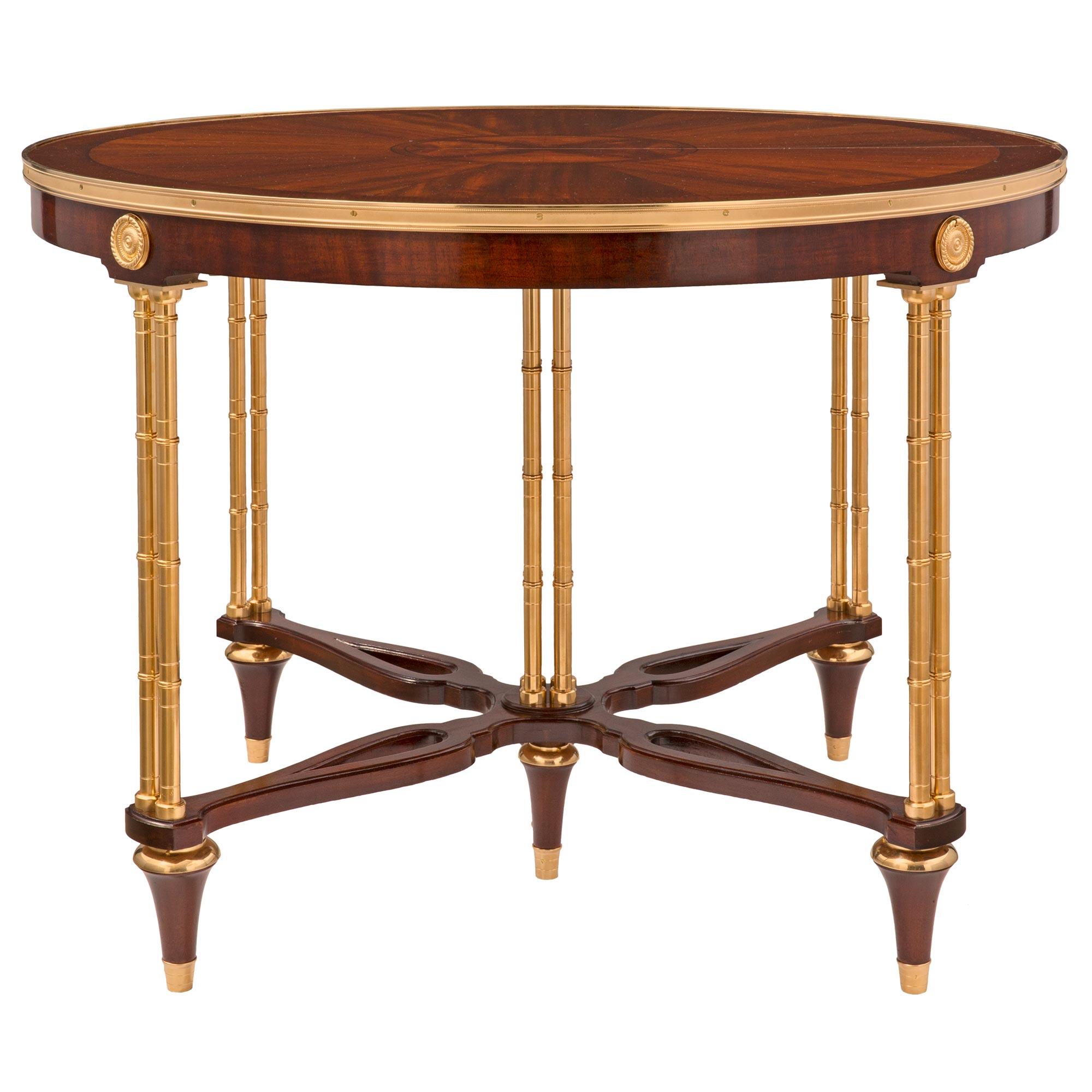 An exceptional and unique French late 19th century Louis XVI st. mahogany and ormolu dining table, after a model by Adam Weisweiler. The table is raised by elegant circular tapered legs with fine topie shaped feet and ormolu top caps. Each leg is