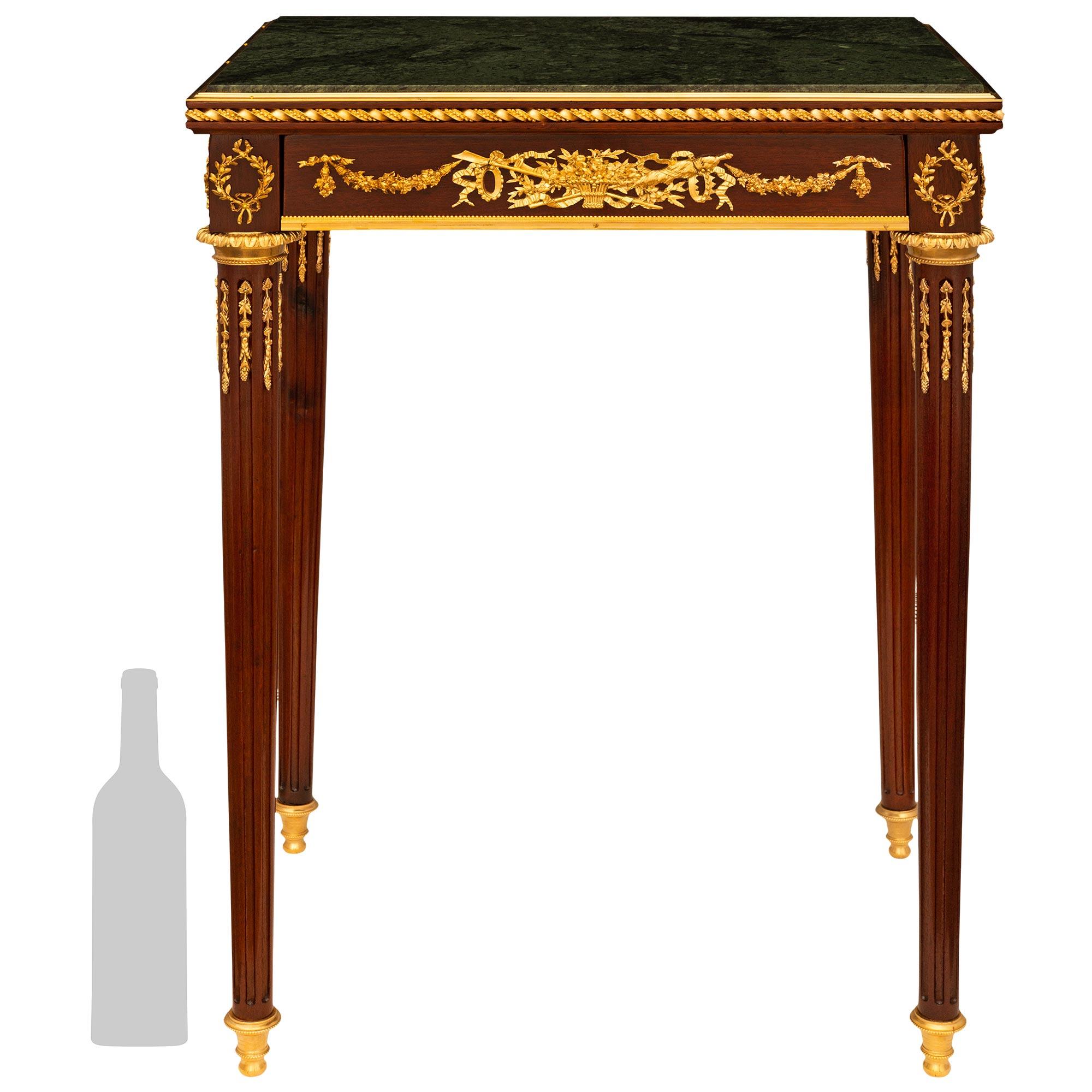 Table d'appoint élégante et très décorative de style Louis XVI de la fin du XIXe siècle, en acajou, bronze doré et marbre vert Verde Antico. Cette merveilleuse table repose sur quatre pieds élancés, fuselés et cannelés, avec des sabots en bronze