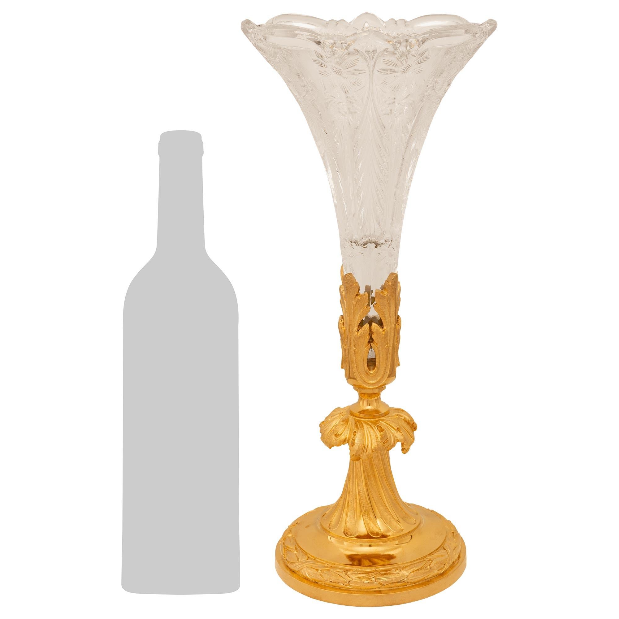 Grazioso e finemente dettagliato vaso francese della fine del XIX secolo in stile Luigi XVI in ormolu e cristallo Baccarat, con timbro Baccarat. Questo vaso bellissimo e molto decorativo è sollevato da una base circolare in Ormolu con bordo