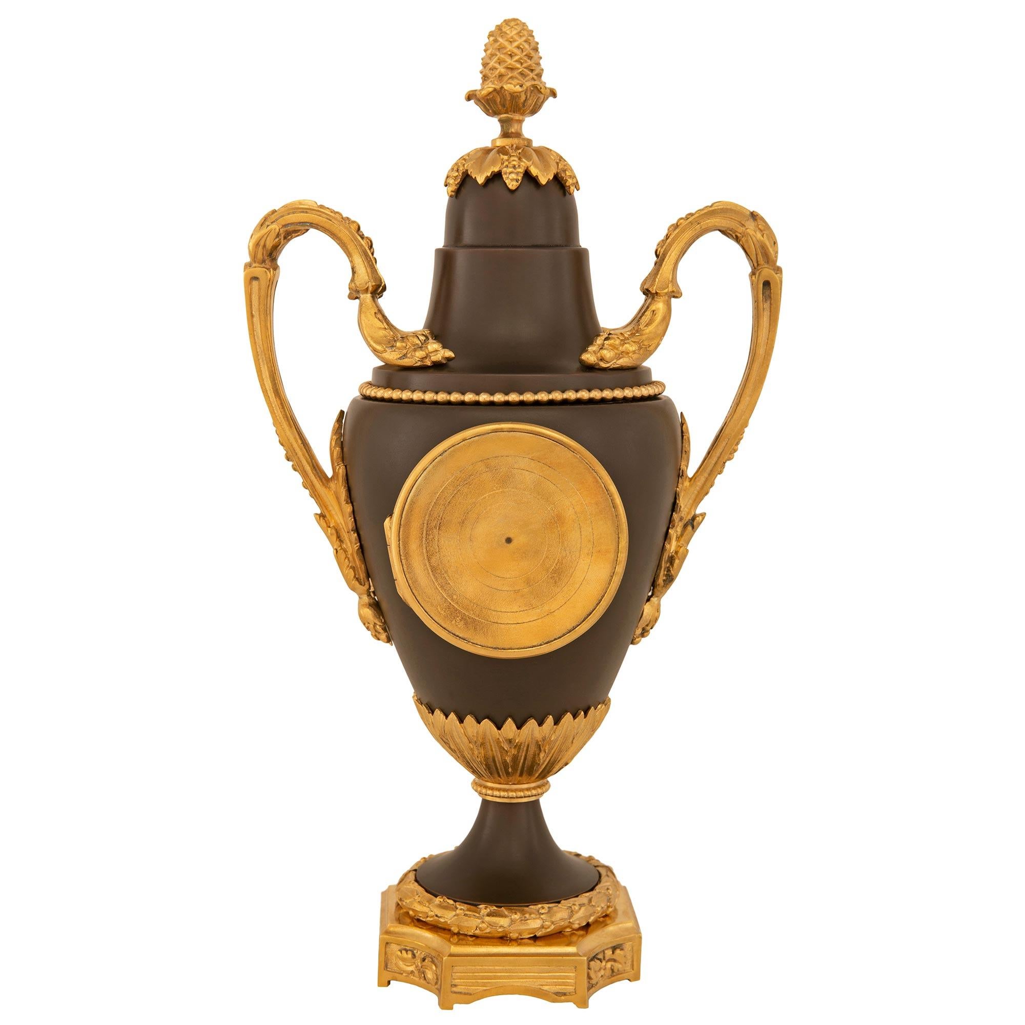 Patiné Horloge en bronze patiné et bronze doré de la fin du XIXe siècle de style Louis XVI en vente
