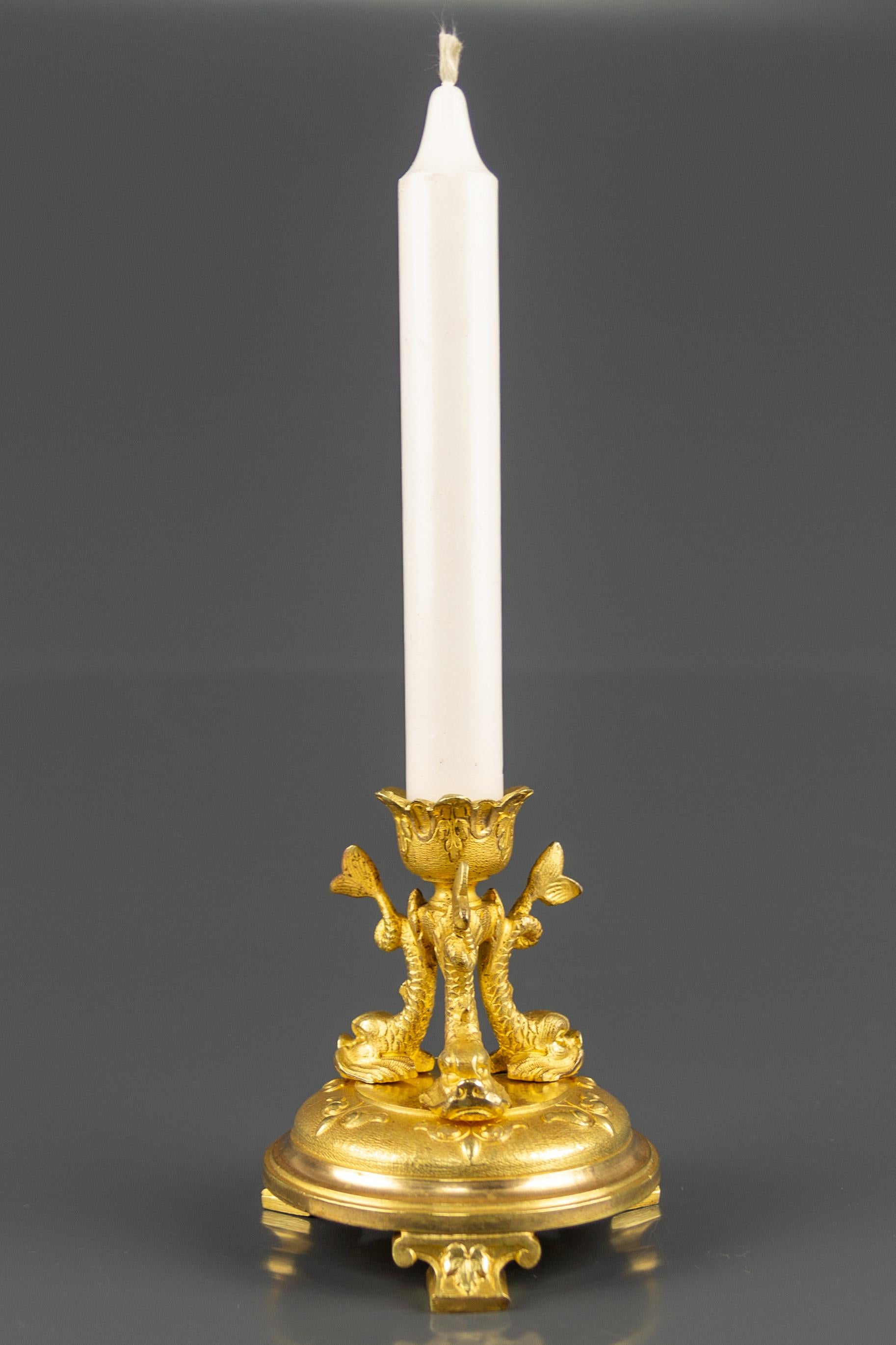 An adorable French gilt bronze candlestick on a circular base with leaves decorations. The candle cup is held by three finely detailed dolphins.
Dimensions: diameter of the base 10 cm / 3.93 in; height 11 cm / 4.33 in.
  