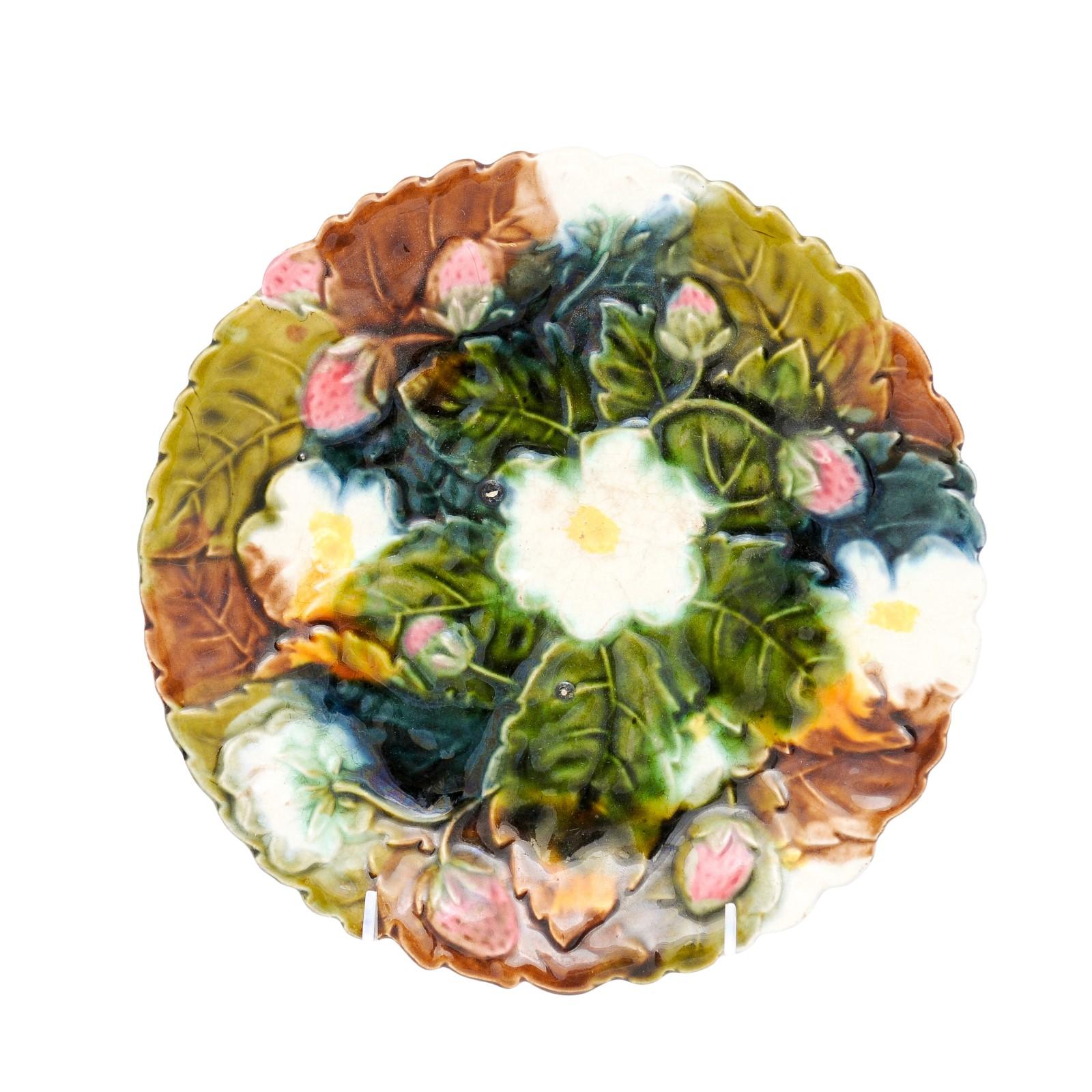 A French majolica barbotine plate from the late 19th century with a décor of strawberries, white flowers, brown, blue and green leaves. Expertly crafted using the Barbotine technique, this plate epitomizes the Majolica style with its vibrant color