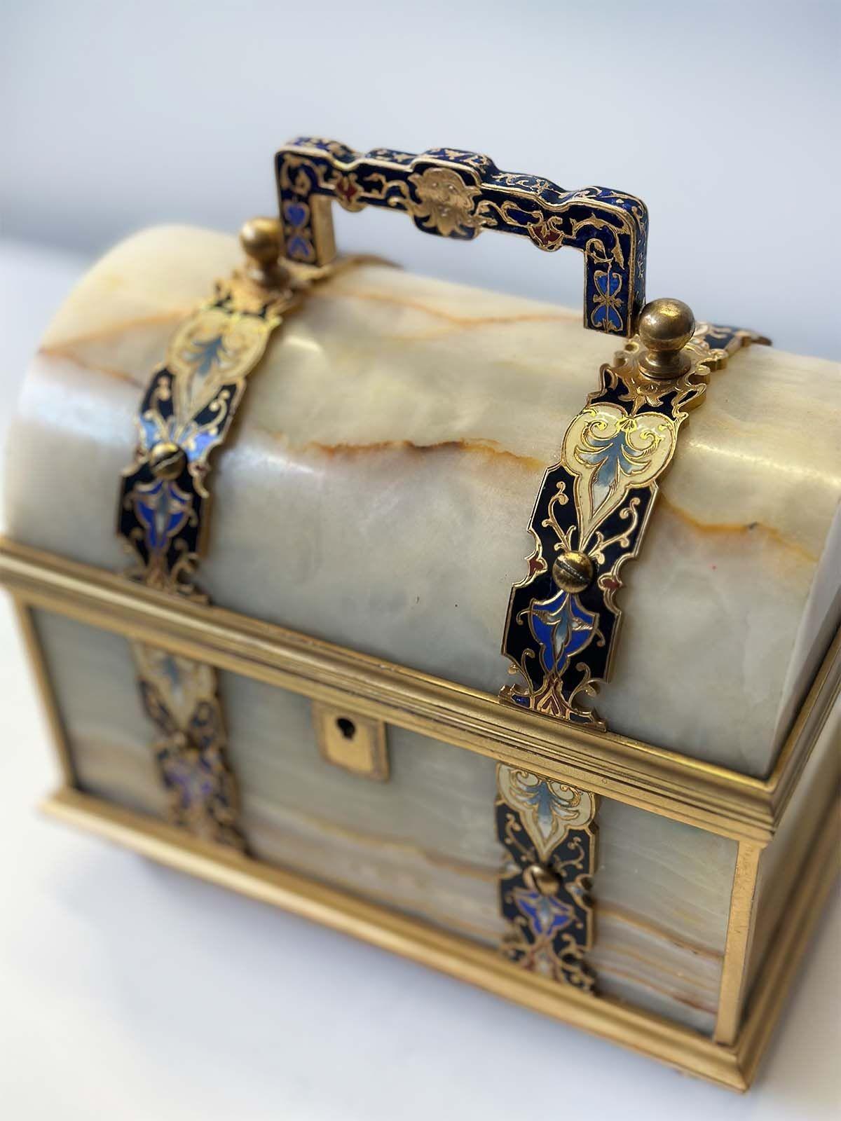 Beautiful onyx and gilt bronze champlevé enamel jewelry box in a chest design; made in France in the Late 19th Century, having a soft red velvet interior and impeccable hand-painted detailing.
Dimensions:
8
