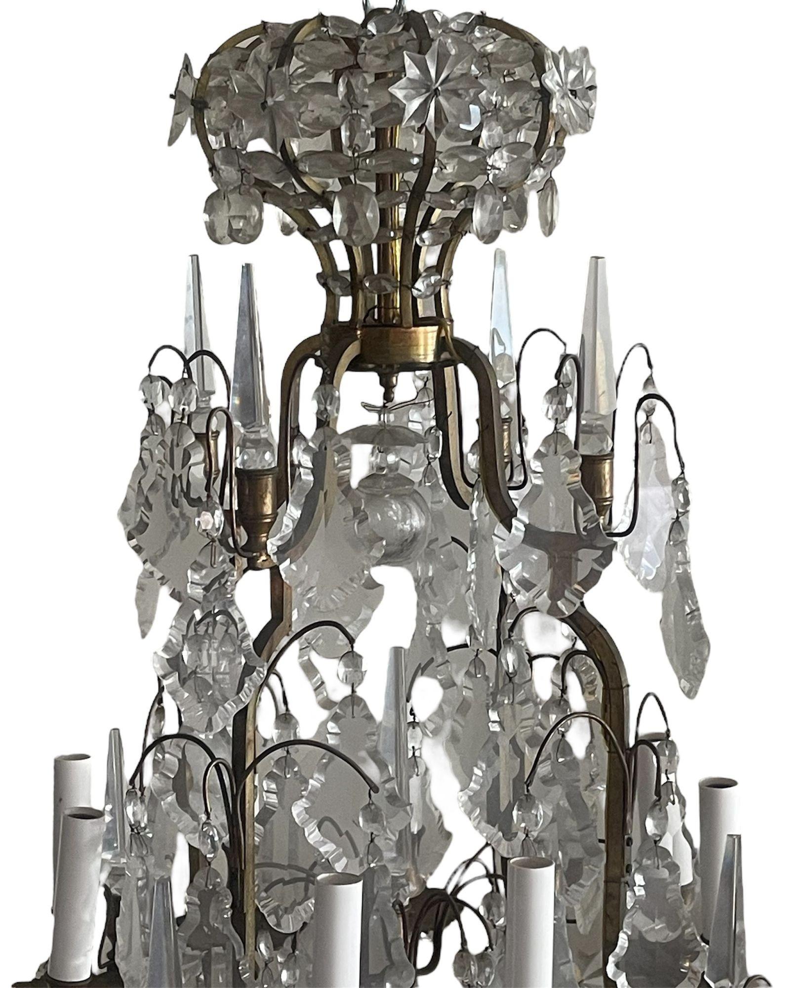 Ein exquisiter französischer Kronleuchter aus dem späten 19. Jahrhundert, aus patinierter Bronze gefertigt und mit einer Fülle von eleganten, handgeschliffenen Kristallelementen verziert. Der Kronleuchter zeichnet sich durch ein königliches