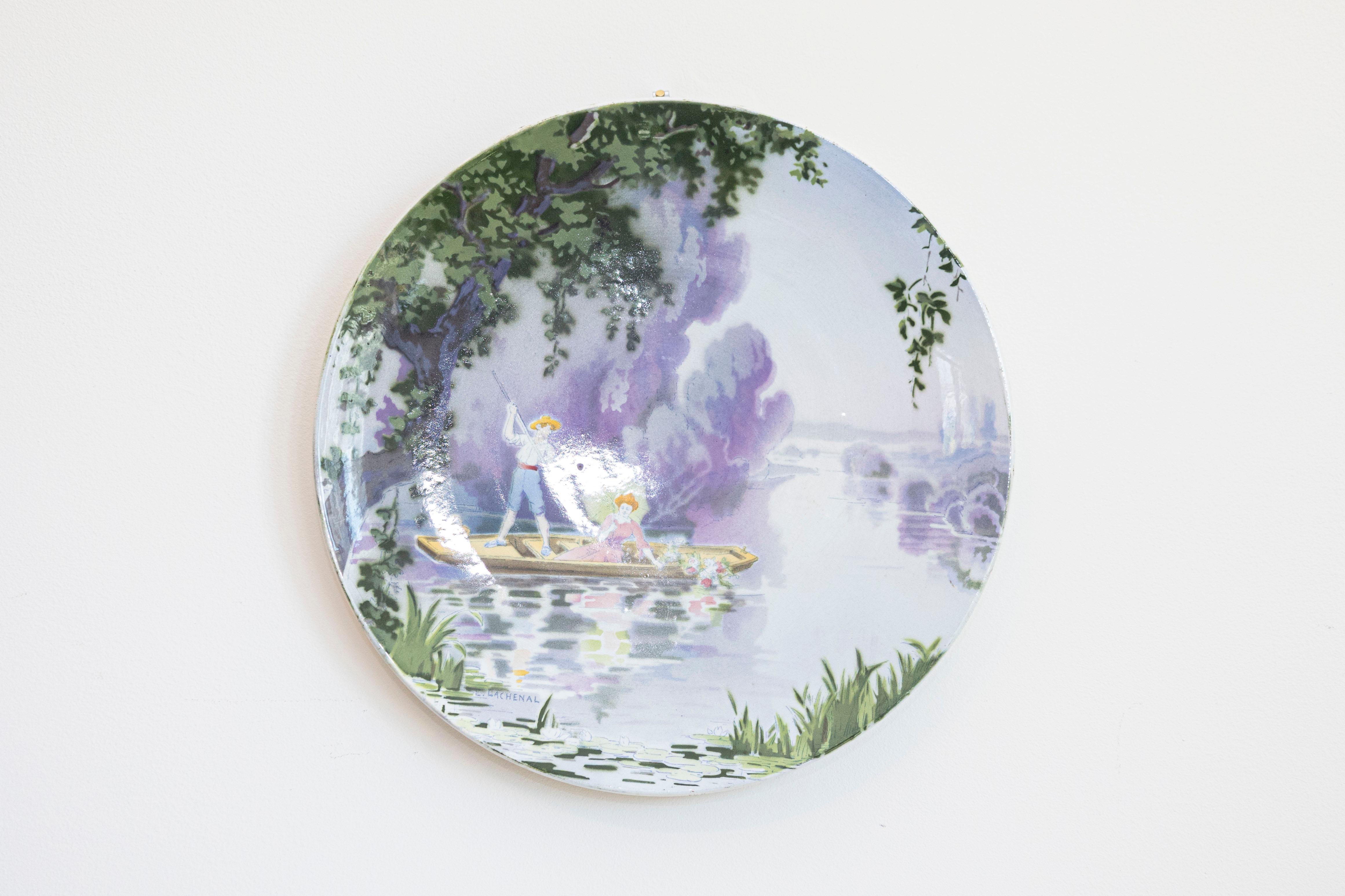 Plato decorativo para colgar de porcelana francesa, obra de Edmond Lachenal (1855-1948), que representa a dos amantes en un barco. Creado en Francia a finales del siglo XIX, este plato de porcelana, obra del ceramista Edmond Lachenal, representa una