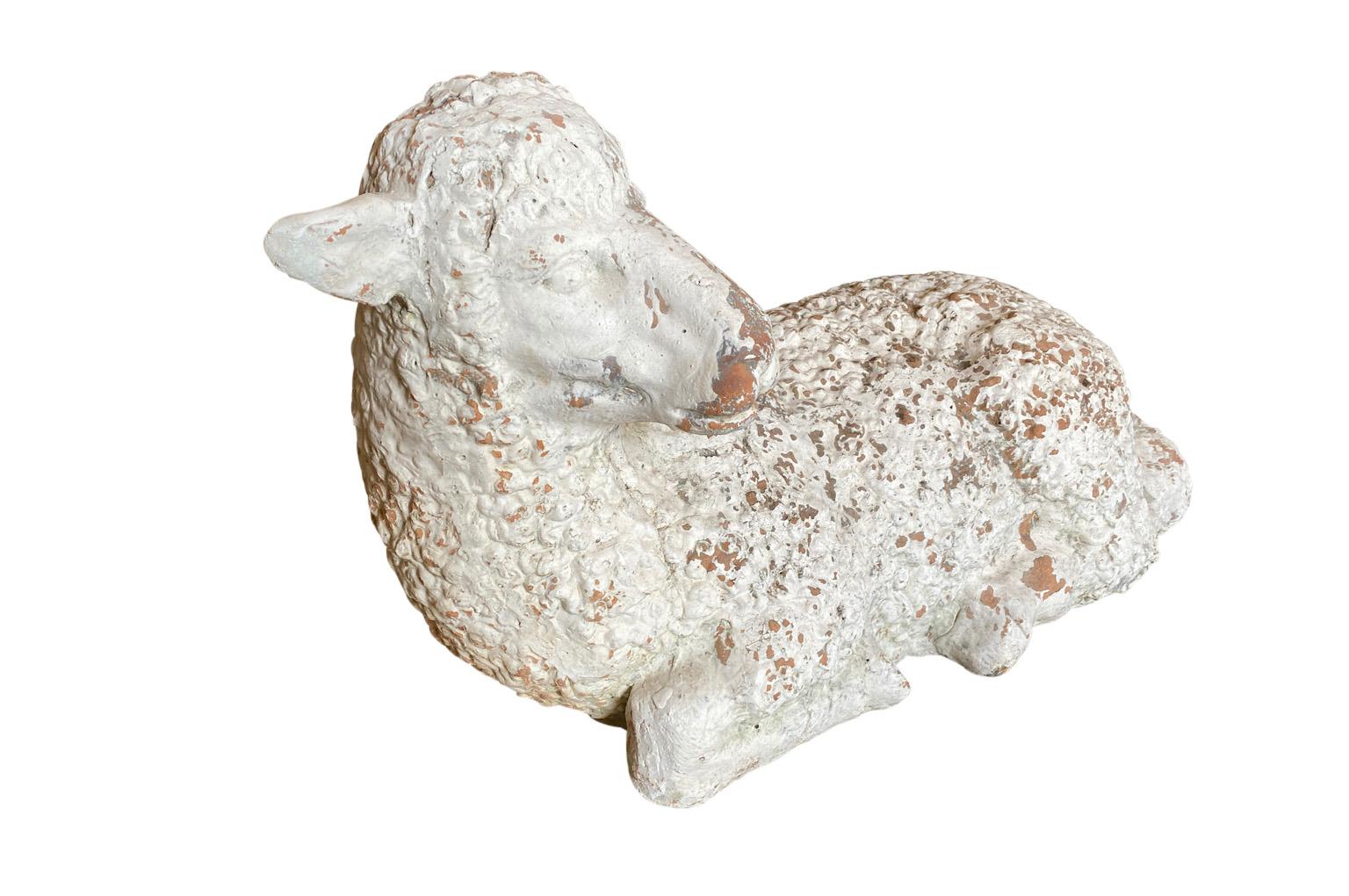 A very charming French later 19th century Lamb - from a creche - in painted terracotta. A very serene accent piece.