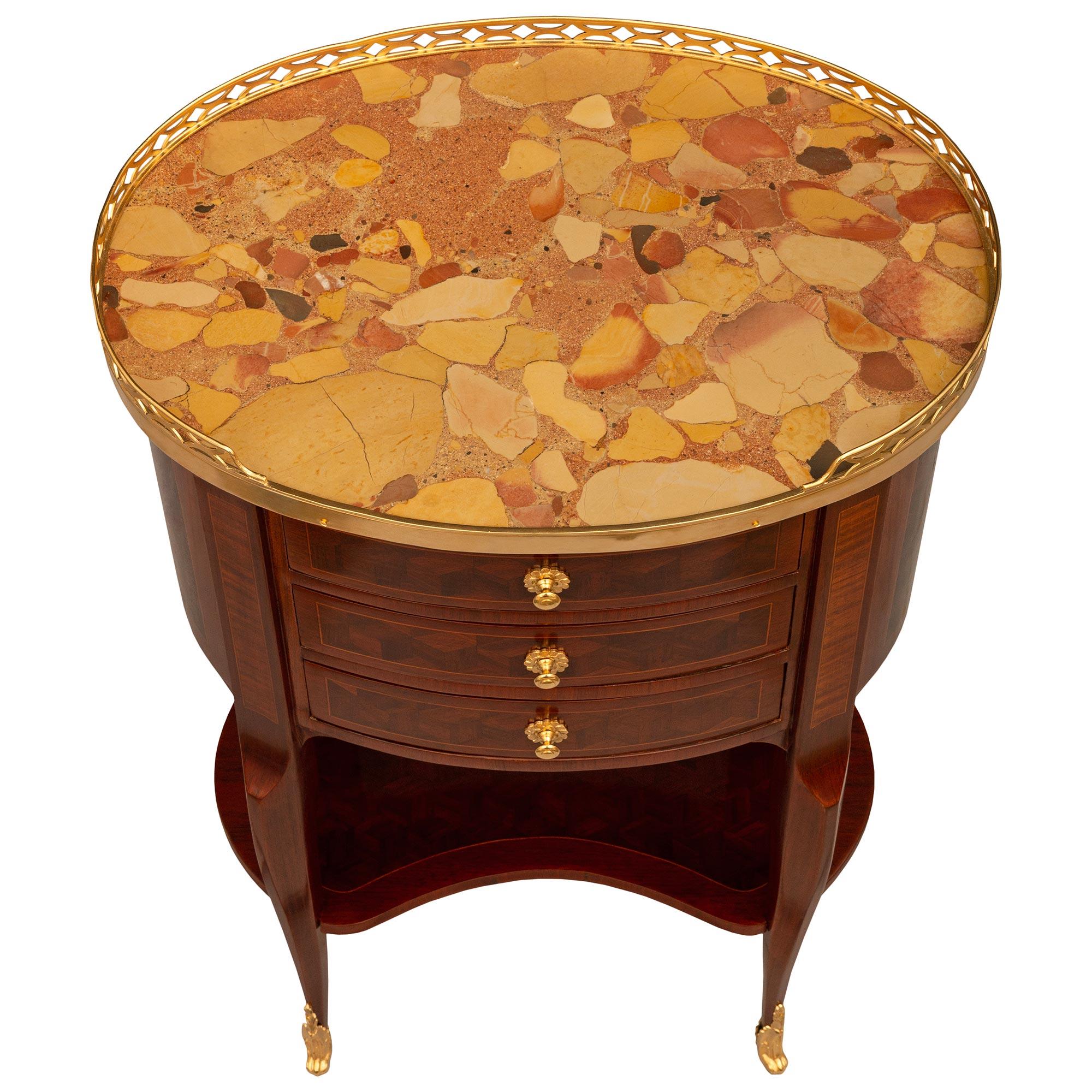 An elegant French late 19th century Transitional st. Tulipwood, Ormolu and Brèche d'Alep marble side table. This beautifully designed three drawer side table is raised on four tapered cabriole legs with wrap around Ormolu sabots with richly chased
