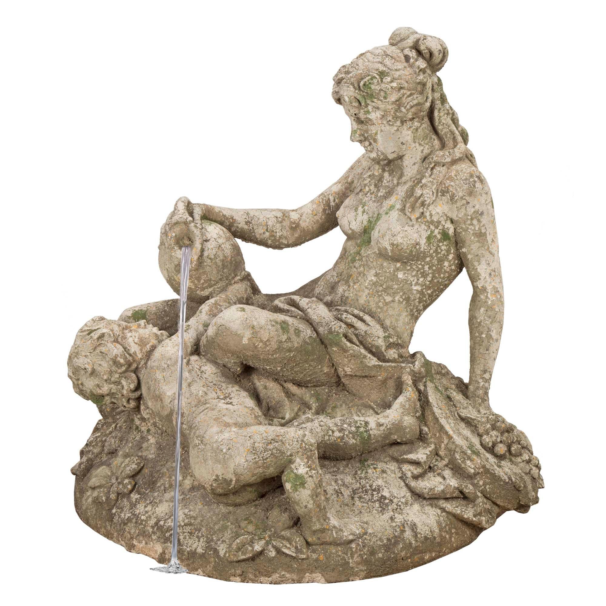 A very unique French late 19th century- Turn of the century fountain. The composite stone fountain is of a mother seated on a rough terrain amidst flowers and foliate, with her child next to her. The woman holds a jug from which flows the fountain,