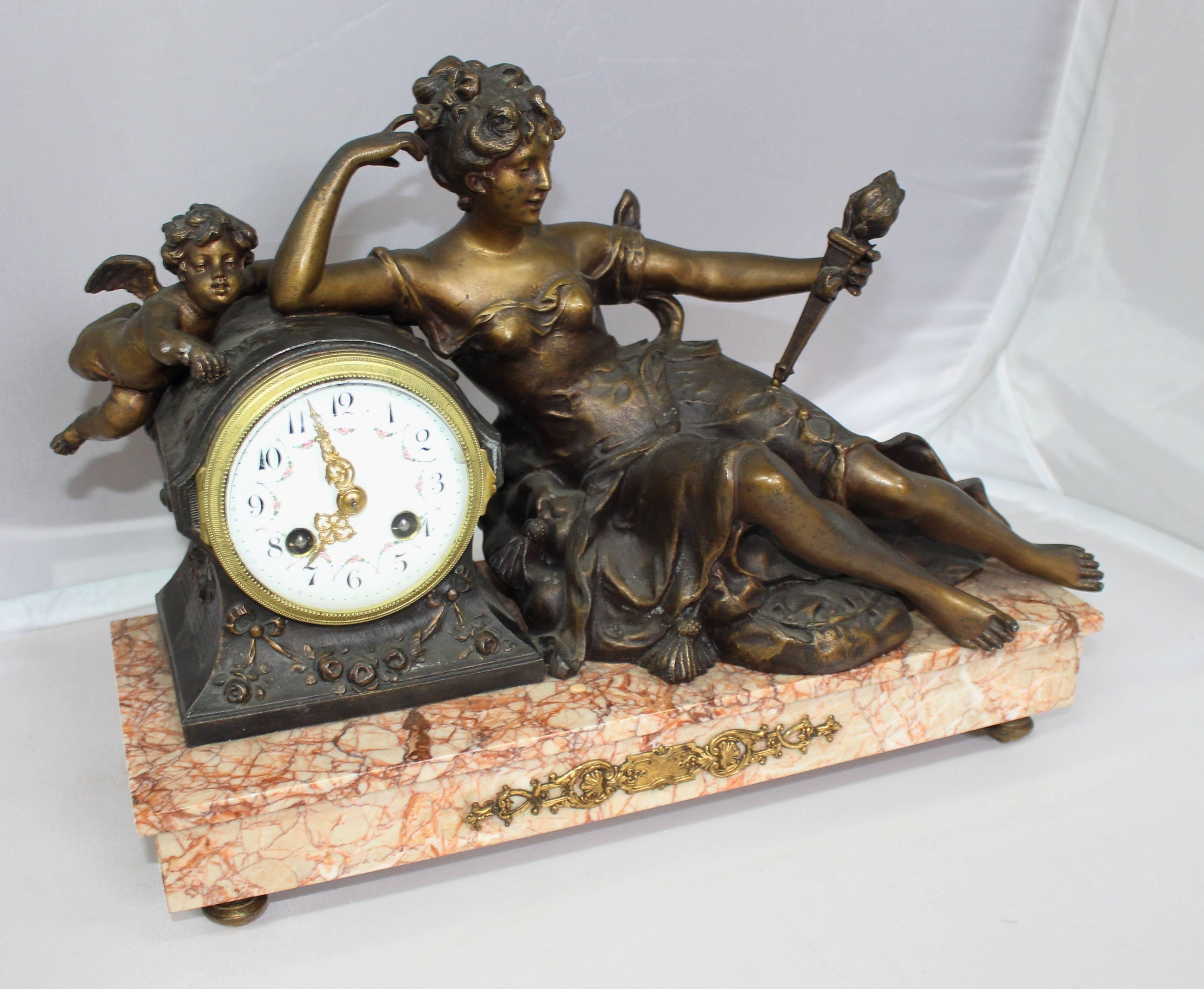 Period 
Late 19th century.

Dial 
enamel dial with painted floral decoration and Arabic numerals, brass hands, two winding holes, brass outer ring

Decoration 
spelter figures abover a rouge marble base with ormolu mounts and feet

Movement