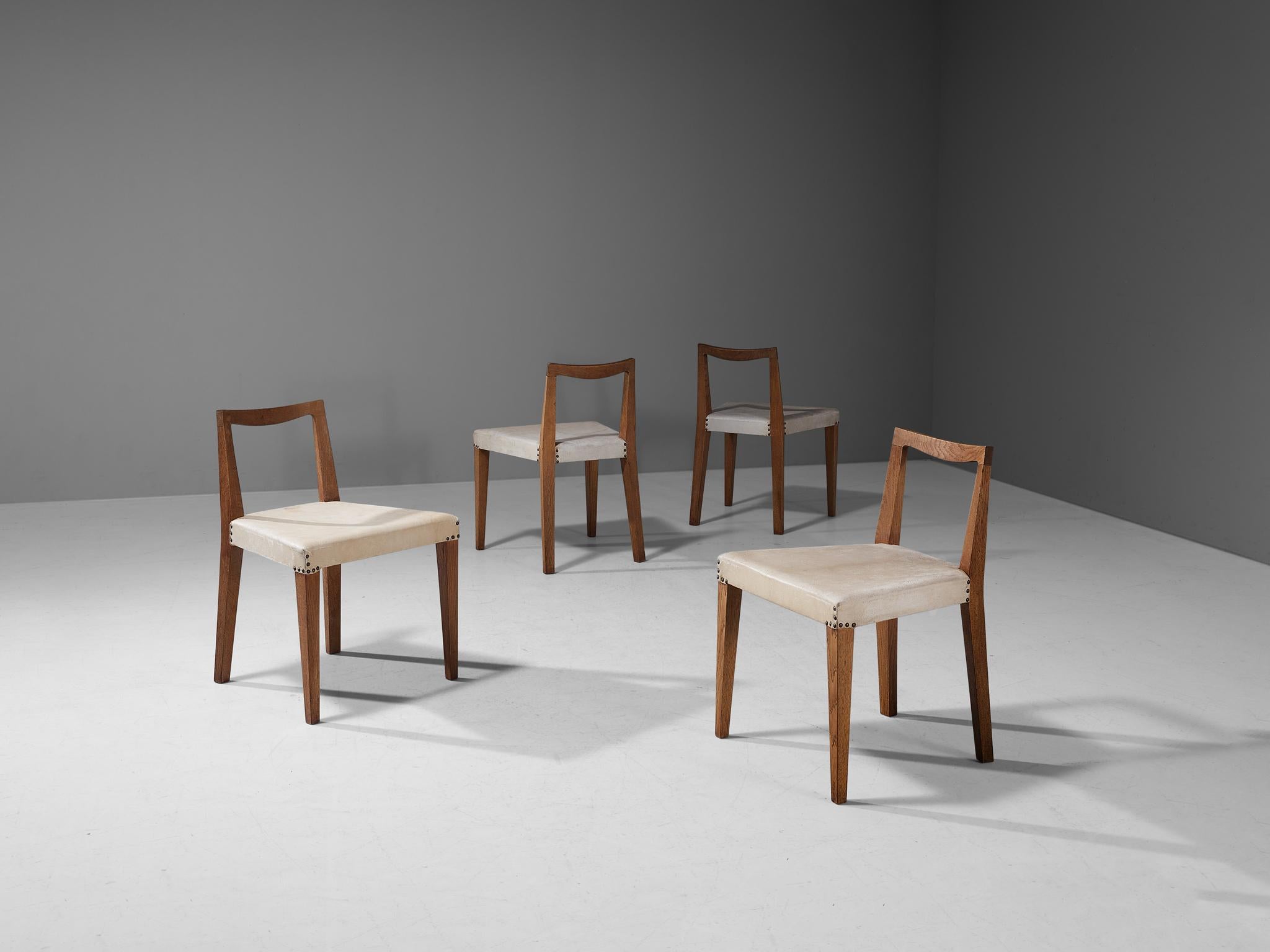 Set of four dining chairs, oak, leather, brass, France, late 1940s 

This well-constructed set of four dining chairs of French origin embodies a splendid structure that shows a simplistic, natural and timeless aesthetics. The design is