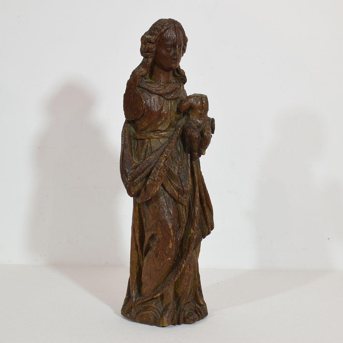 Beautiful early oak statue of a Madonna with child. Clearly visible that this statue has suffered a bit but still beautiful and very strong expression. France, circa 1550. Weathered and losses.