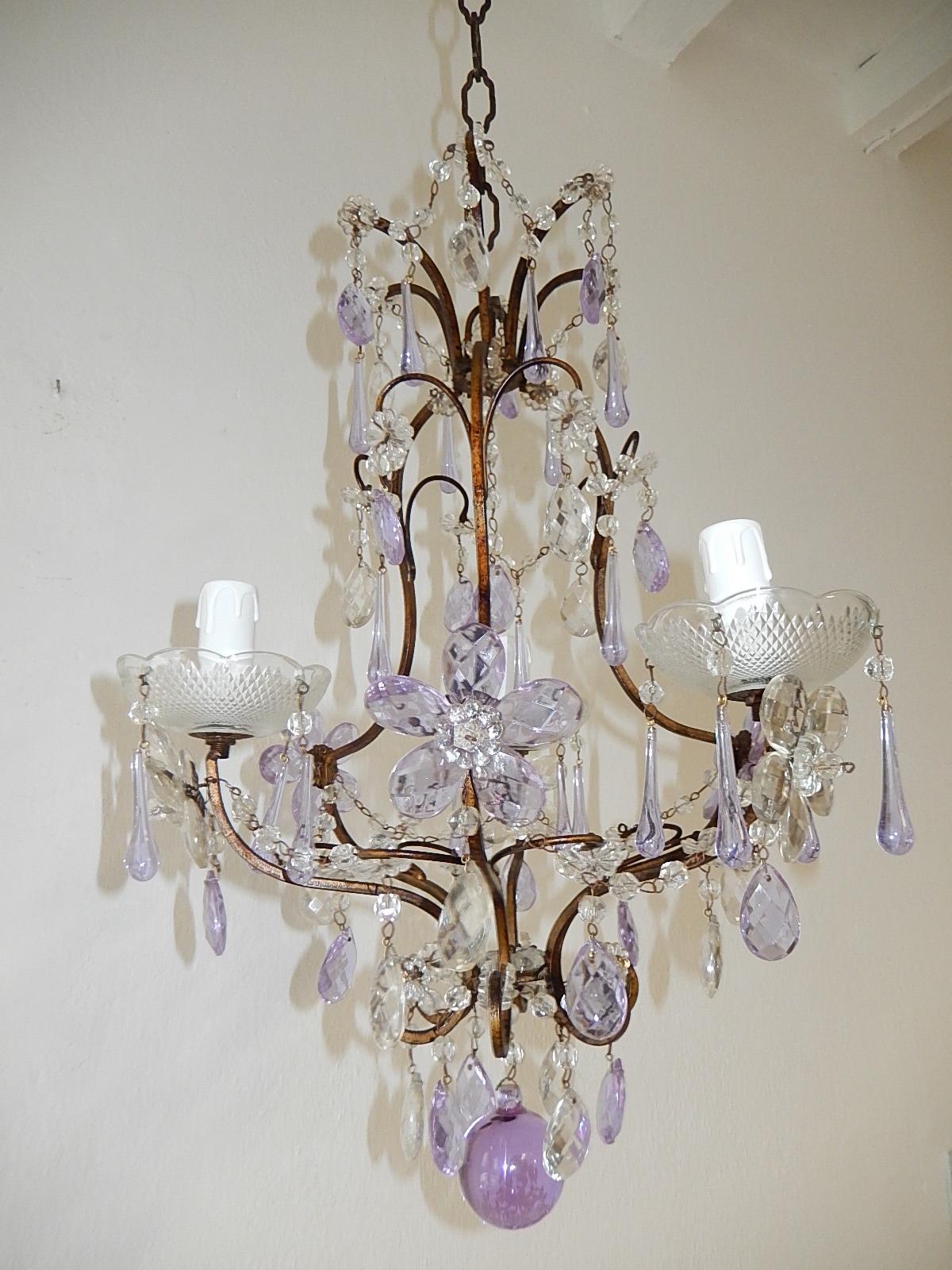 Housing 3 lights, sitting in crystal bobeches dripping with lavender Murano drops. Rewired with appropriate certified sockets for country and ready to hang. Swags of crystal beads and florets throughout. Also adorning lavender and clear crystal