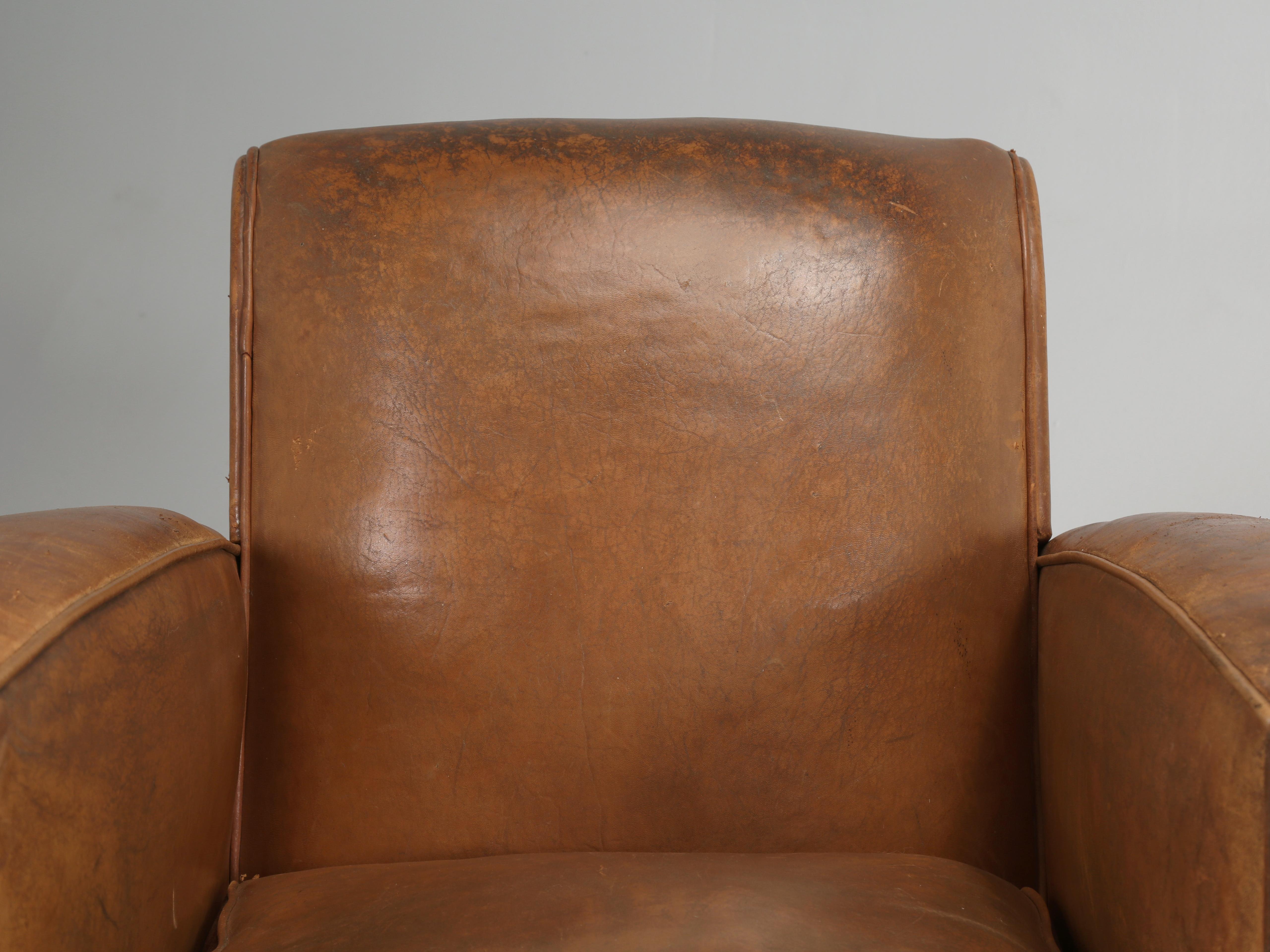 Pair of French Leather Club Chairs that have been completely disassembled down to the bare wood frames and everything inside has been properly restored to as new condition. All of the leather on the exterior is old and there are zero new leather