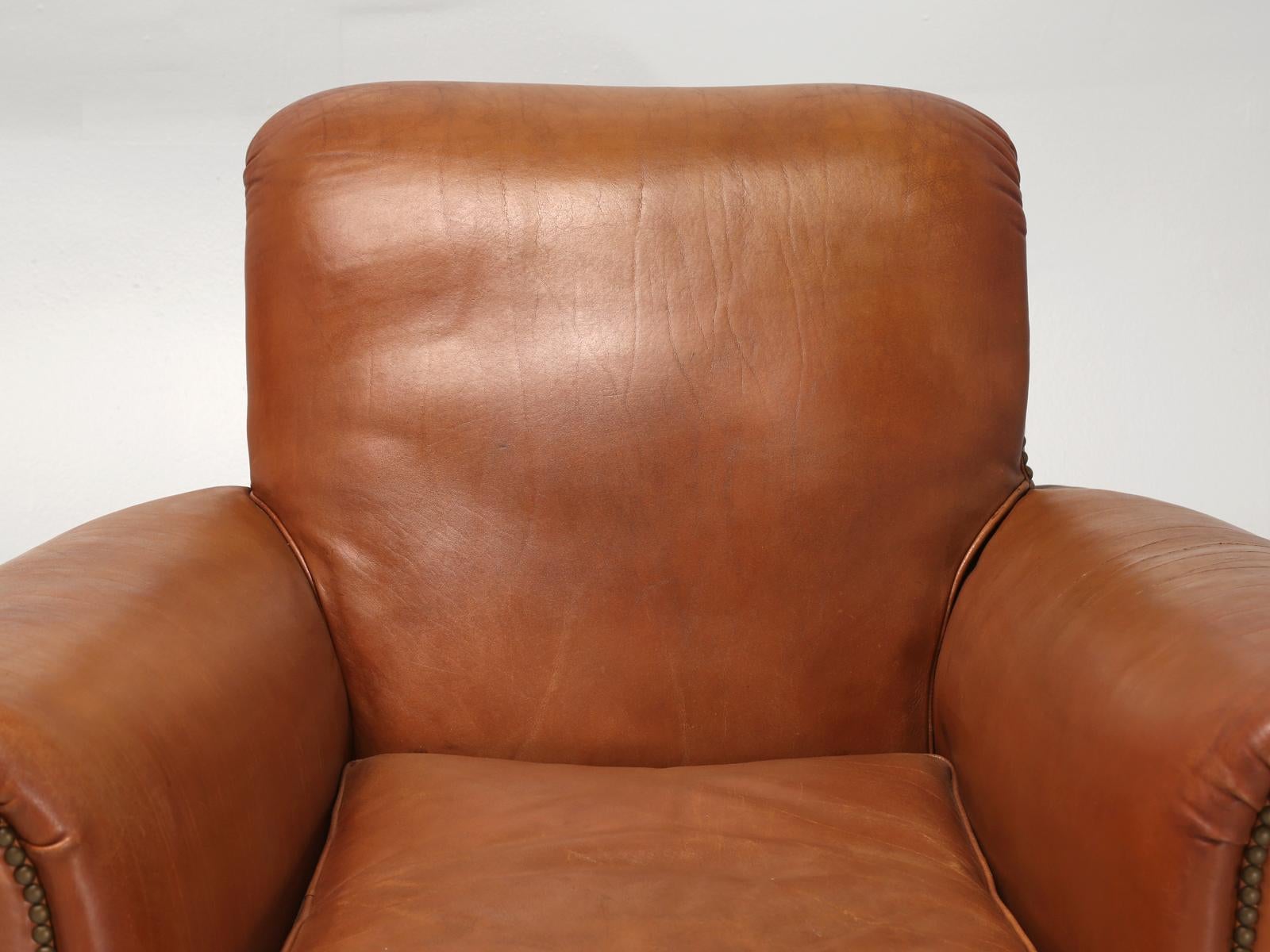 French leather club chairs that our in house Old Plank upholstery department restored internally, while leaving all of the leather original. The condition of the lamb hides are incredibly still soft and supple. This particular pair still has the