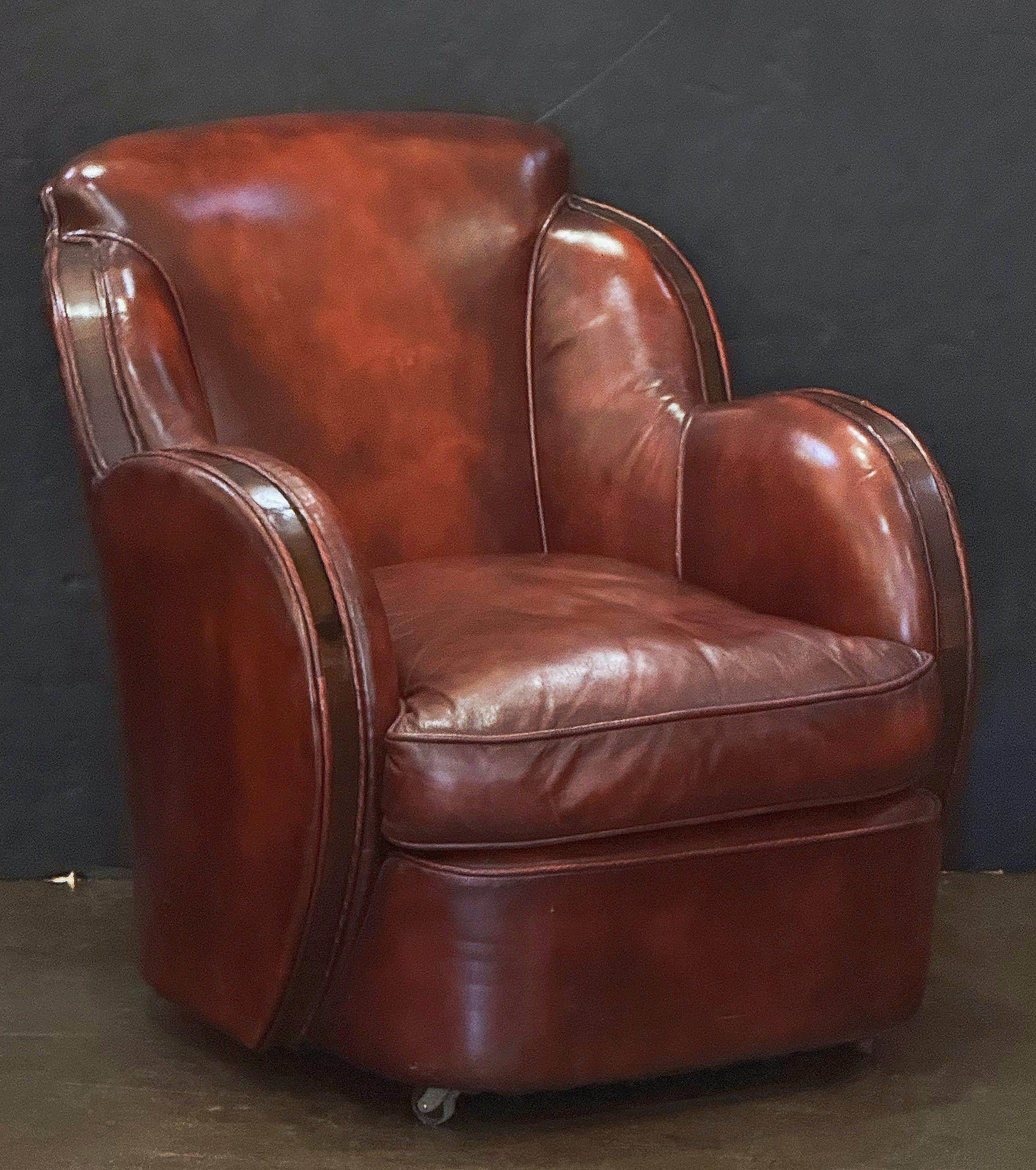 Fino sillón francés de época Art Déco, tapizado en cuero, con cómodo respaldo y asiento moldeados, cojín extraíble, brazos de elegante diseño tapizados en madera y cuero original, sobre ruedas pivotantes.

La altura del asiento es de 17 pulgadas