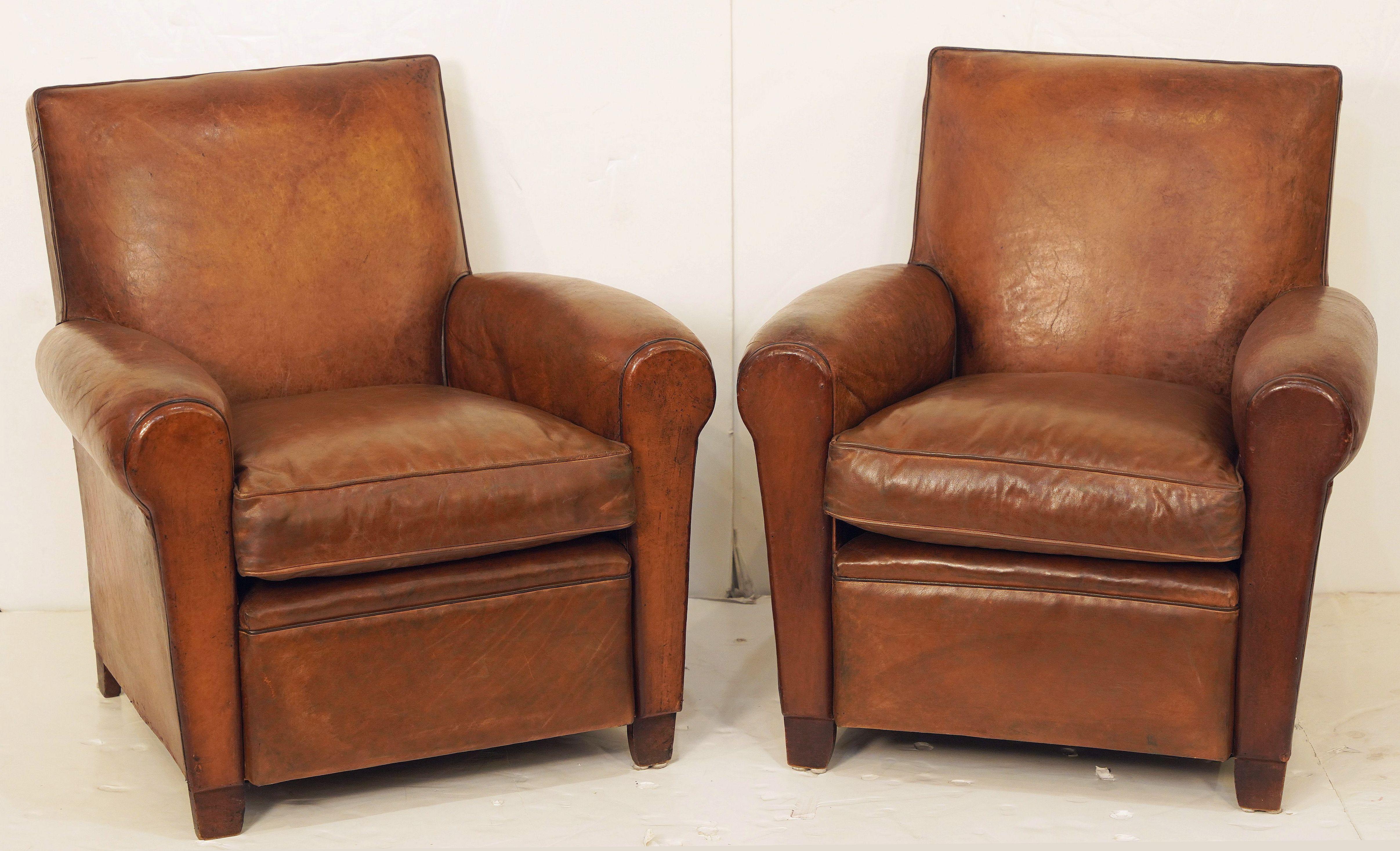 A handsome vintage French leather upholstered club or lounge chair from the Art Deco era - the chair featuring a comfortable shaped back and seat with removable cushion, with stylish arms and original leather, brass nail-head trim to back, and