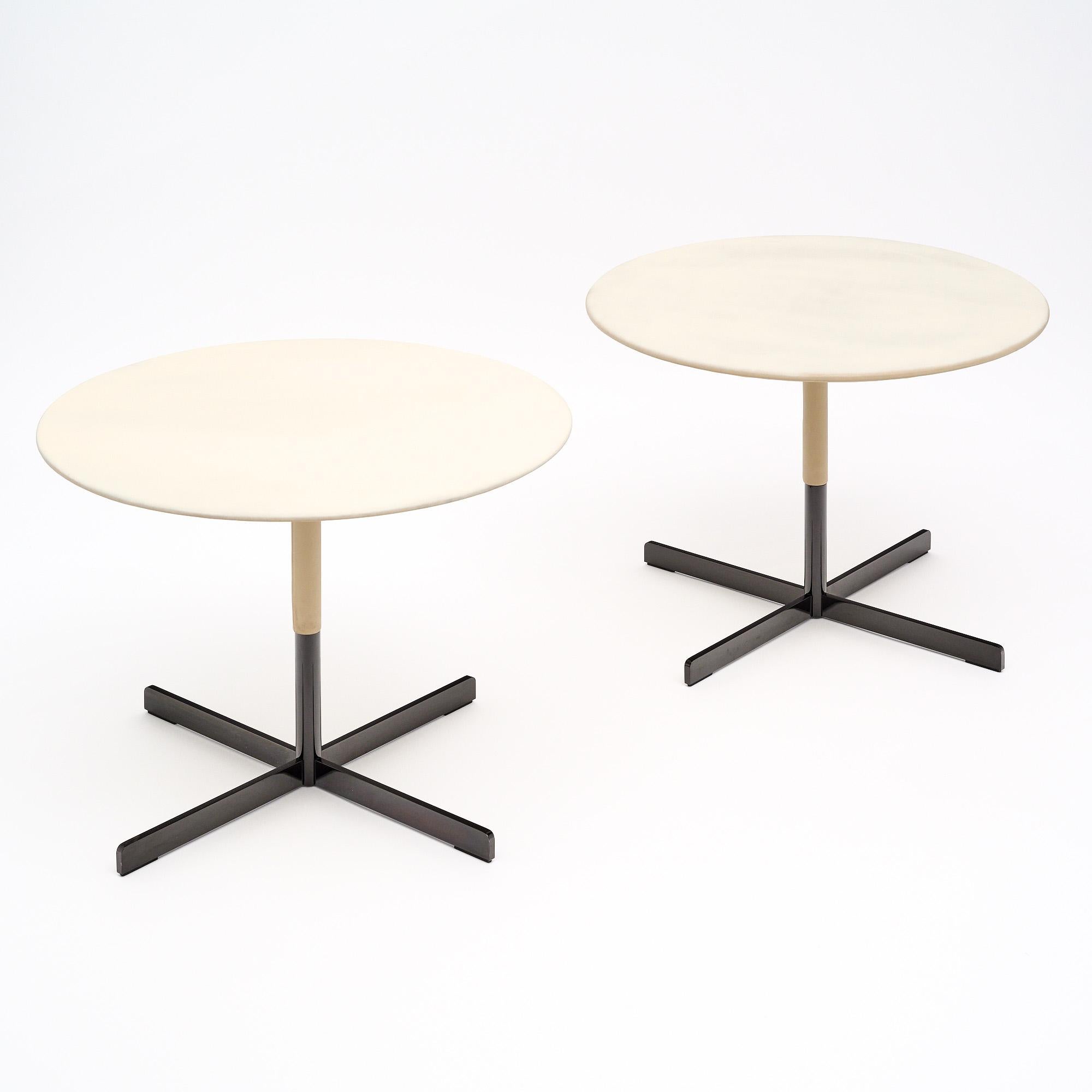 Tables d'appoint françaises du milieu du siècle. Cette paire a des plateaux circulaires et une base en acier. Les dessus sont recouverts de cuir blanc d'origine de la paire. Ils sont en très bon état et ne présentent qu'une usure superficielle