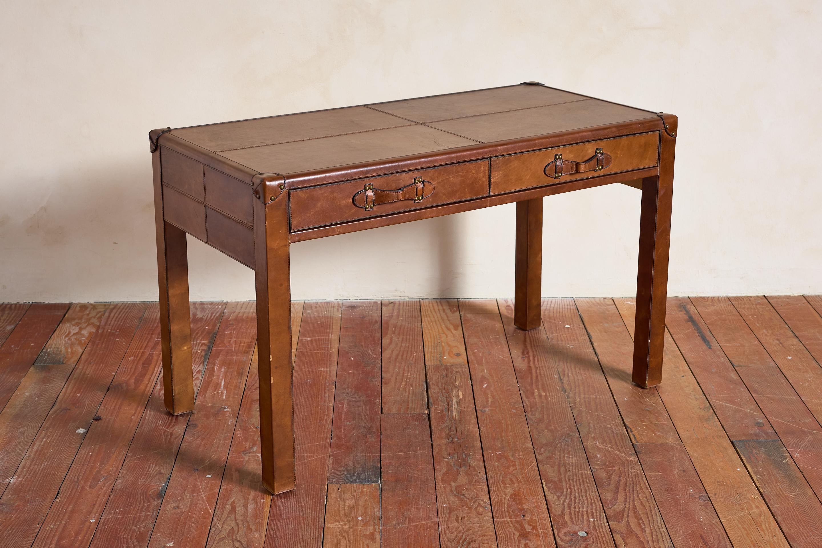 Petite French leather desk with beautiful pantina'd leather

Two drawers with leather pulls and brass studded details and contrast stitched corners 


