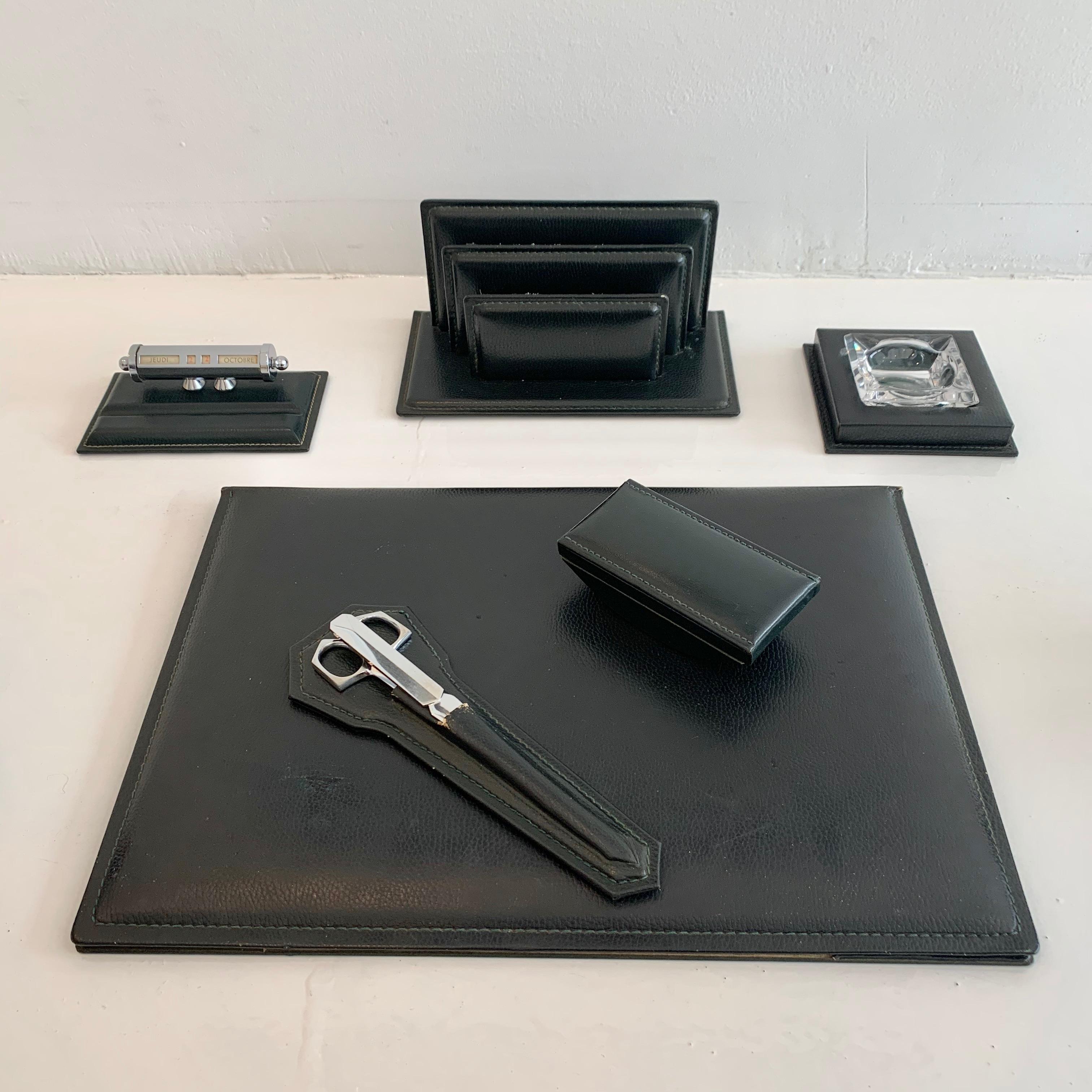 Fantastic 6-piece French leather desk set by Le Tanneur. All pieces wrapped in dark green leather. Desk set includes: desk pad, ink blotter, mail holder, ashtray, adjustable calendar, chrome scissors and letter opener. Good vintage condition. Super