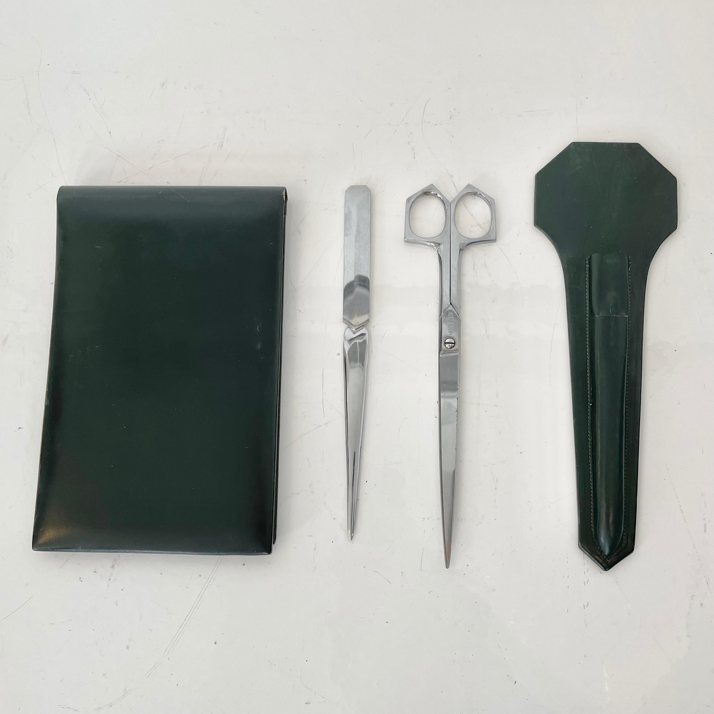 Fantastic 3-piece French leather desk set by Le Tanneur. All pieces wrapped in dark green leather. Desk set includes: note pad, letter opener, scissors. Letter opener and scissors fit snuggly in a carrying case. Good vintage condition. Super elegant