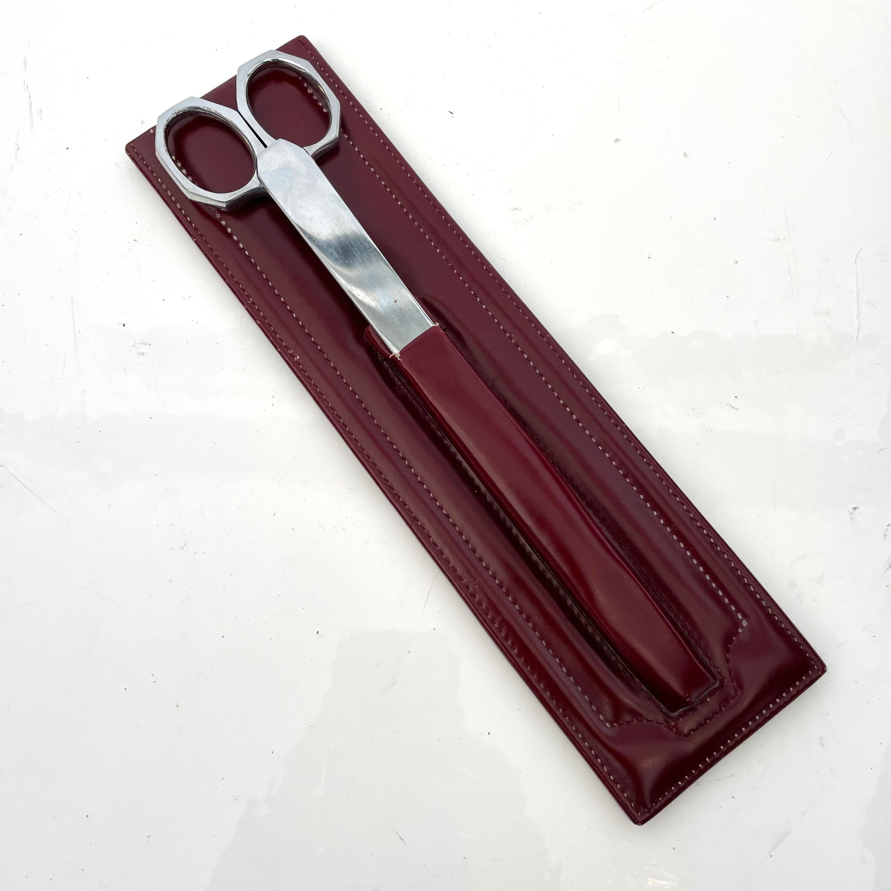 Classic leather desk set with chrome letter opener and scissors. Burgundy leather holding case. Marked made in France and Nogent. Good vintage condition to metal and leather.