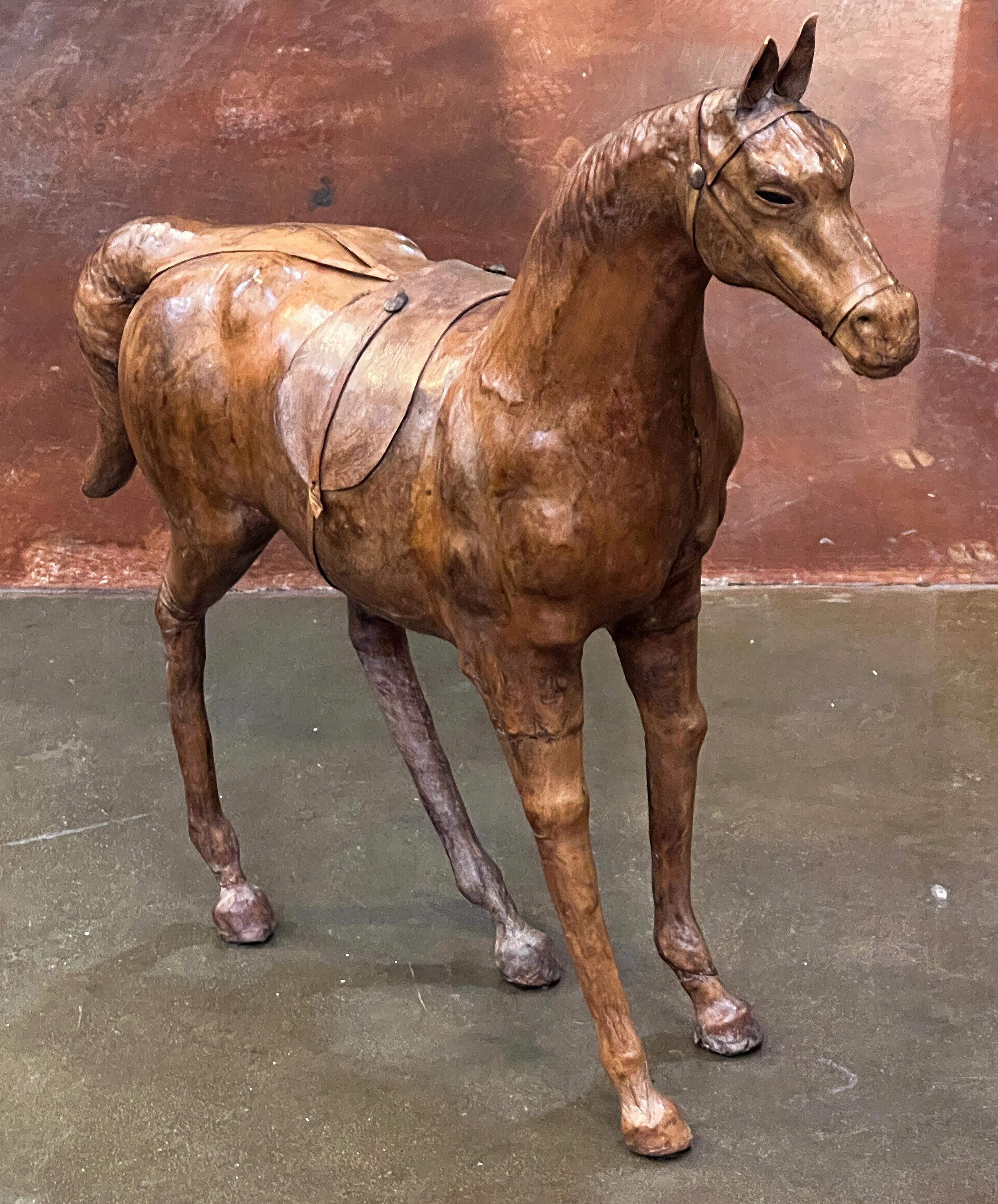 Un beau modèle de cheval décoratif français en cuir avec selle, vers 1880 à 1900, reposant sur quatre pattes et présentant de fins détails à la tête et au corps.

Un cadeau idéal pour un cavalier !