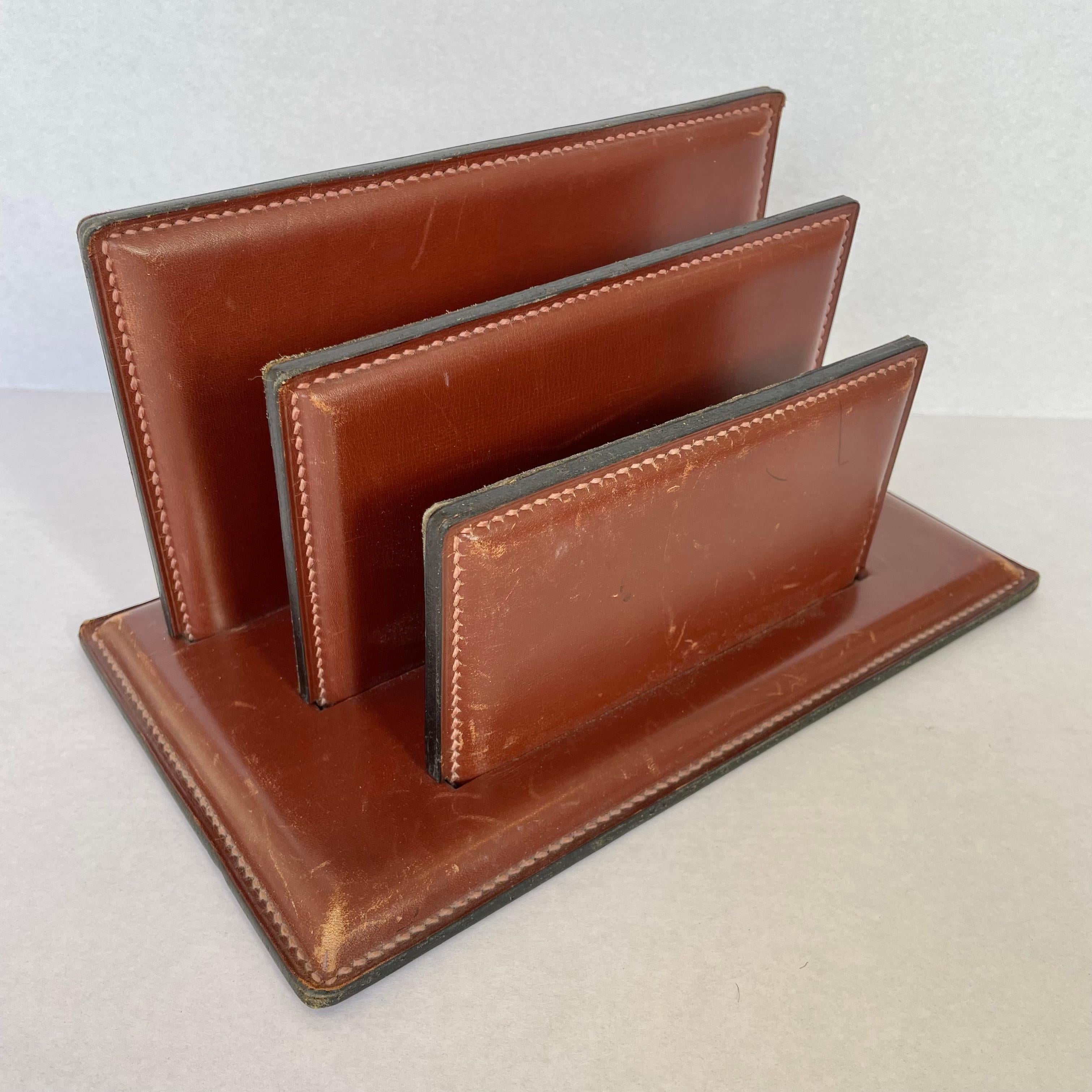Classy French leather mail organizer in the style of Jacques Adnet. Wrapped in thick saddle leather, this organizer is stamped with its address of origin in Paris. The base is stamped 